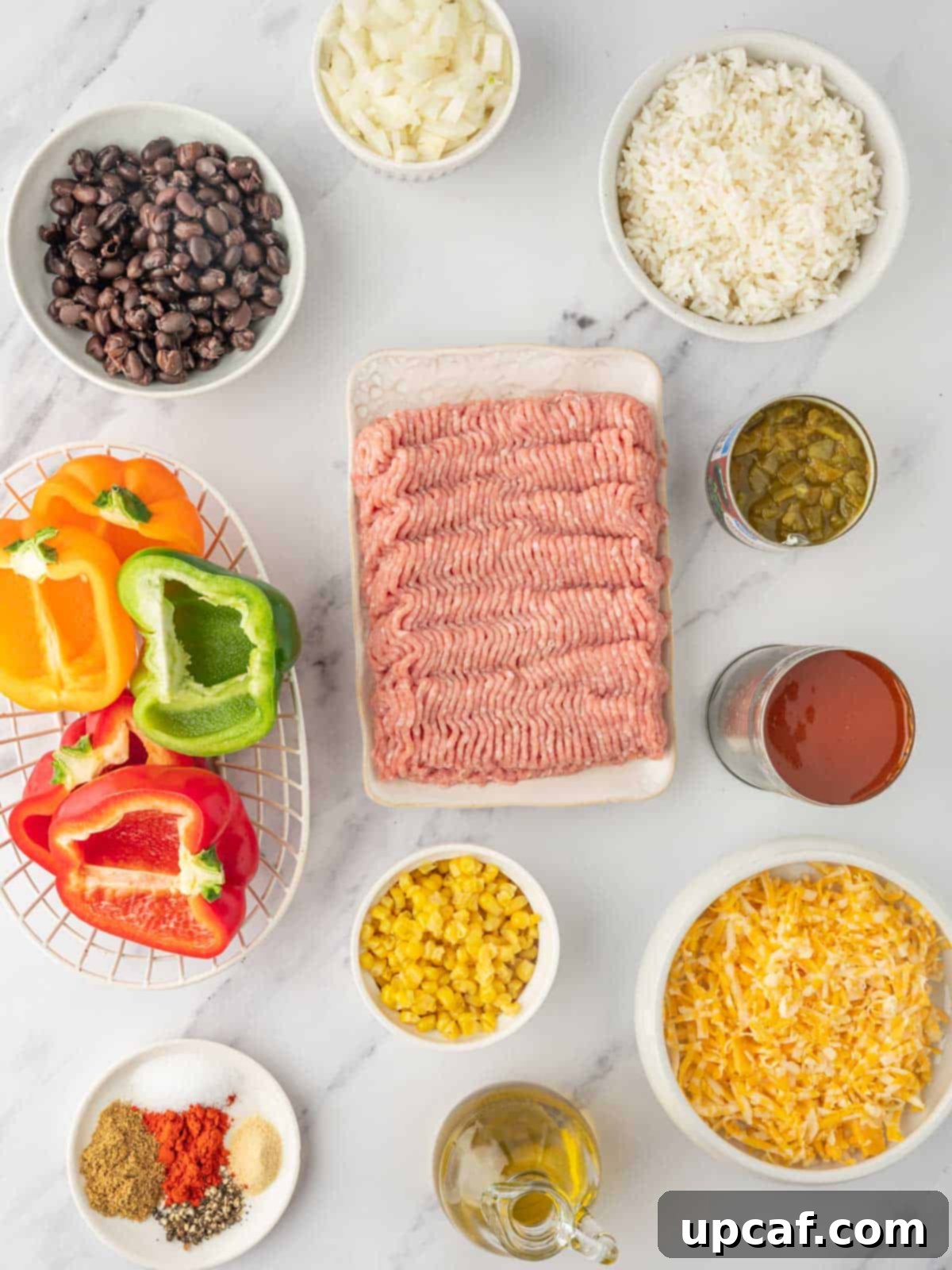 A selection of fresh ingredients laid out, including bell peppers, spices, ground turkey, and cheese, ready for making stuffed air fryer bell peppers.