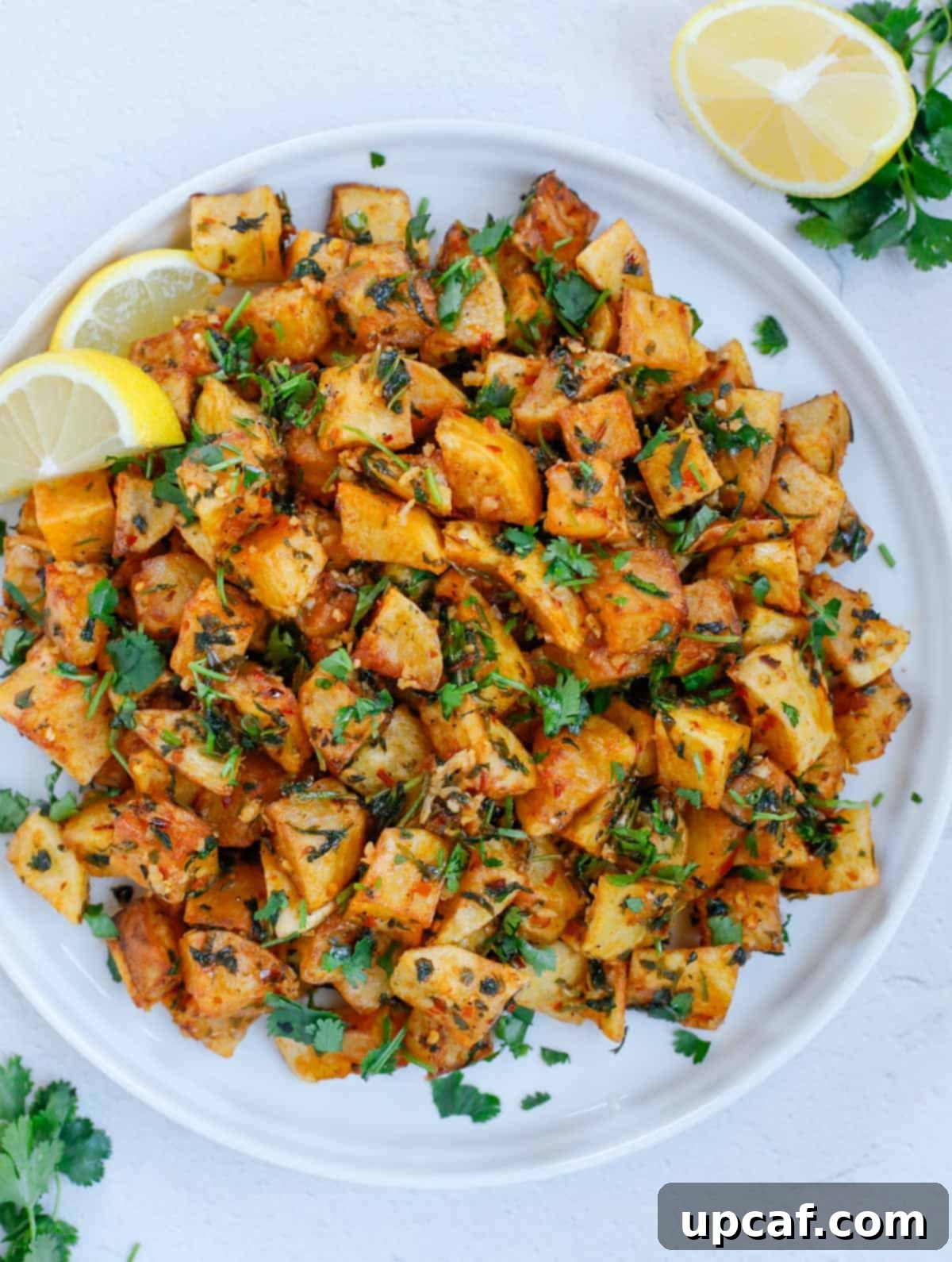 A serving of crispy Lebanese Batata Harra on a white plate, garnished with fresh cilantro.