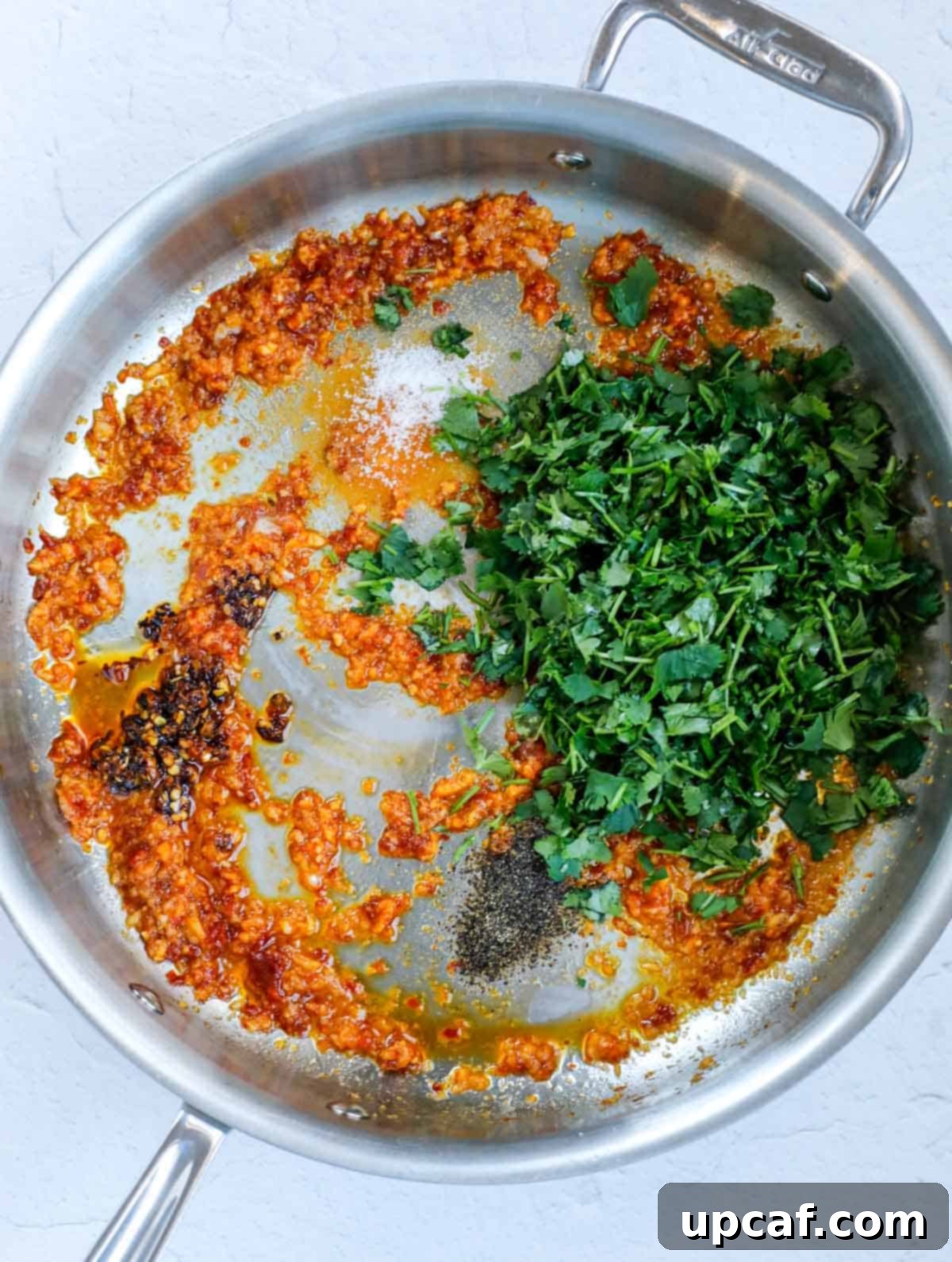 A vibrant mixture of garlic, cilantro, and spices simmering in a pan, ready for the potatoes.