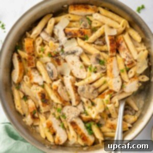 Creamy Garlic Parmesan Chicken Pasta 9 A spoon scoops a portion of garlic parm chicken pasta.
