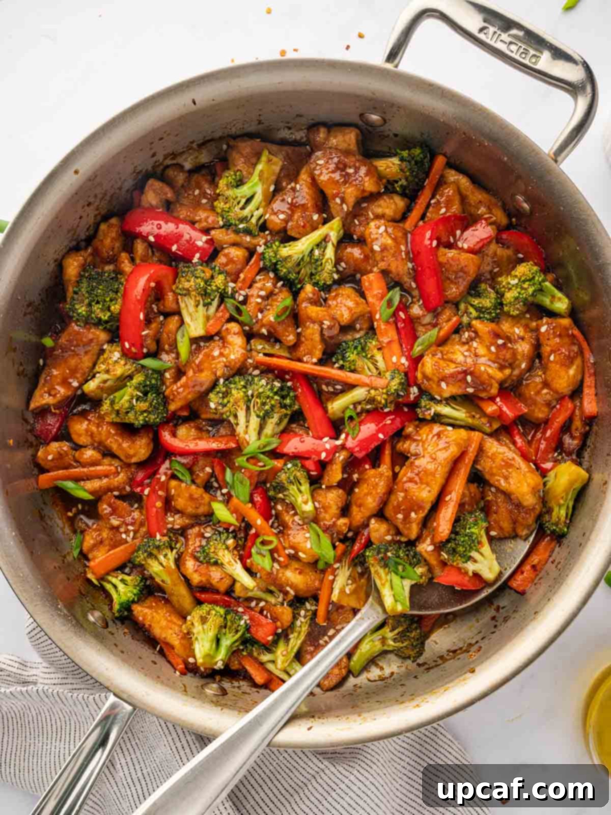 Hunan chicken recipe in a skillet with a spoon.