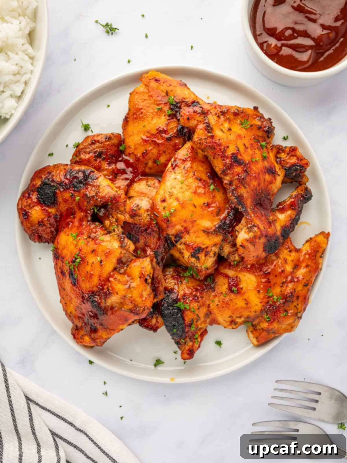 Perfectly Baked Boneless BBQ Chicken Thighs 7 Barbecue chicken thighs on a plate, ready to be served.