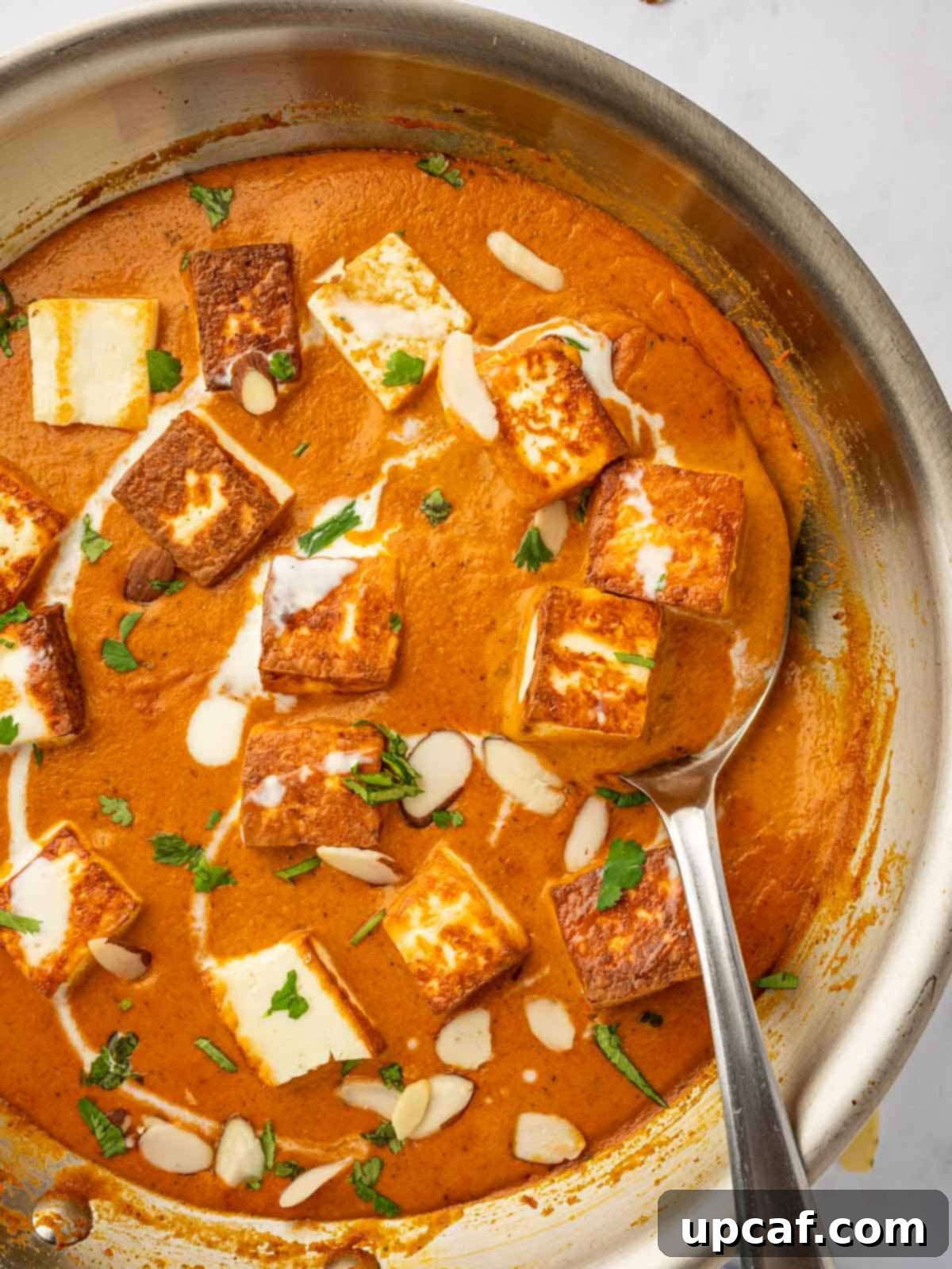 Closeup of paneer pasanda in a skillet, highlighting the rich, thick gravy and tender paneer pieces, ready to be served.