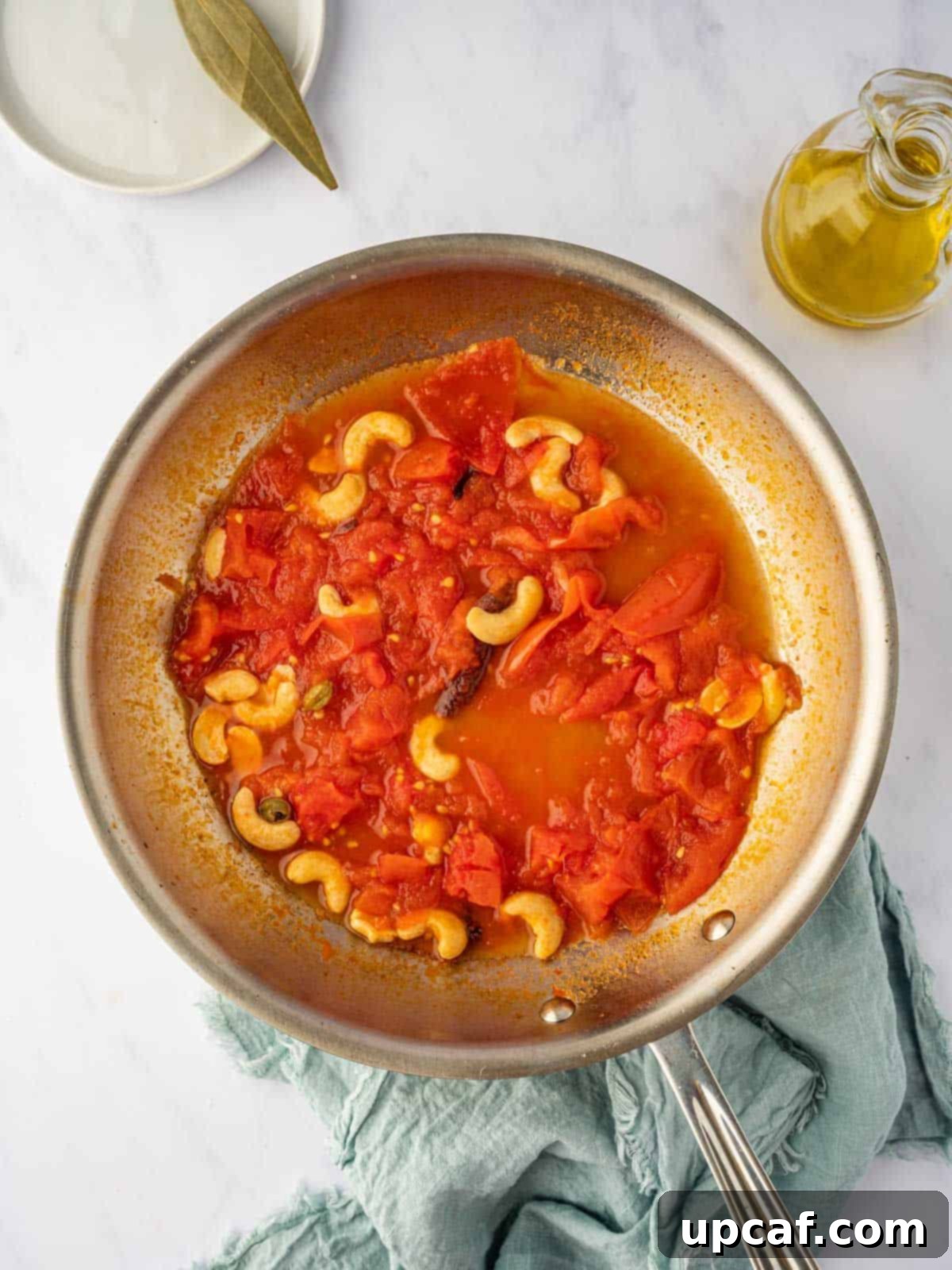 Another perspective of the simmering tomato and cashew sauce, indicating its readiness for blending into a smooth paste.