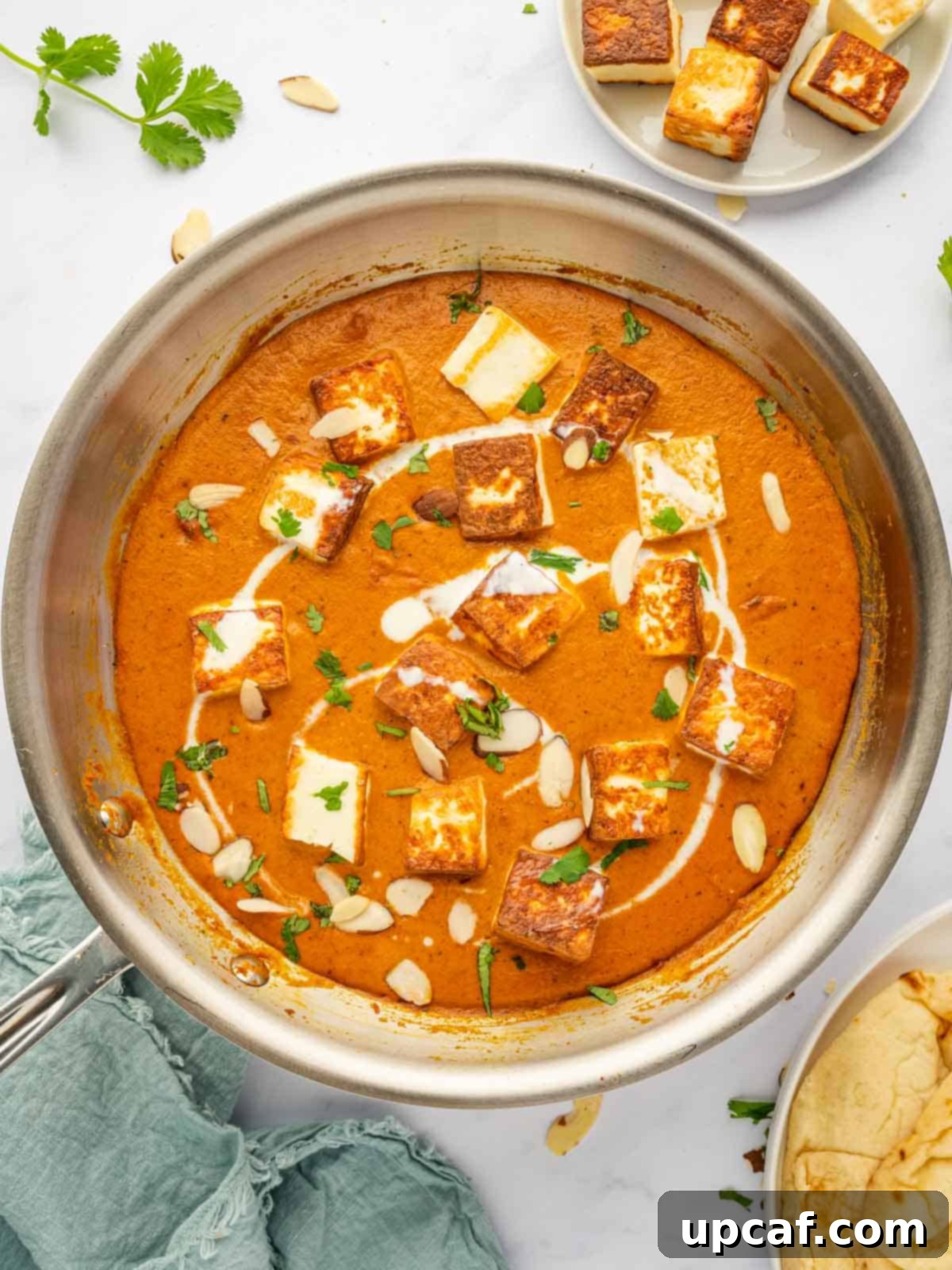 A skillet filled with paneer pasanda, featuring the rich, creamy sauce and tender paneer cubes, ready for final garnishing.