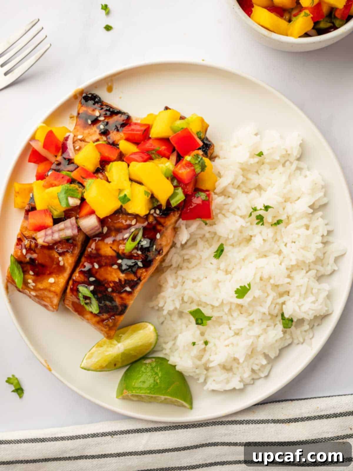 Sweet and Savory Teriyaki Salmon 8 A fully plated grilled teriyaki salmon dish with rice and lime wedges, emphasizing its complete and appealing presentation.