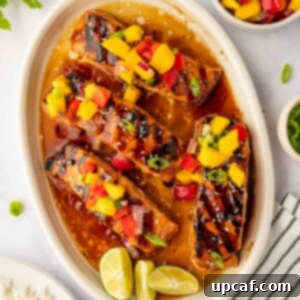 Sweet and Savory Teriyaki Salmon 9 Grilled salmon on a plate topped with mango salsa.