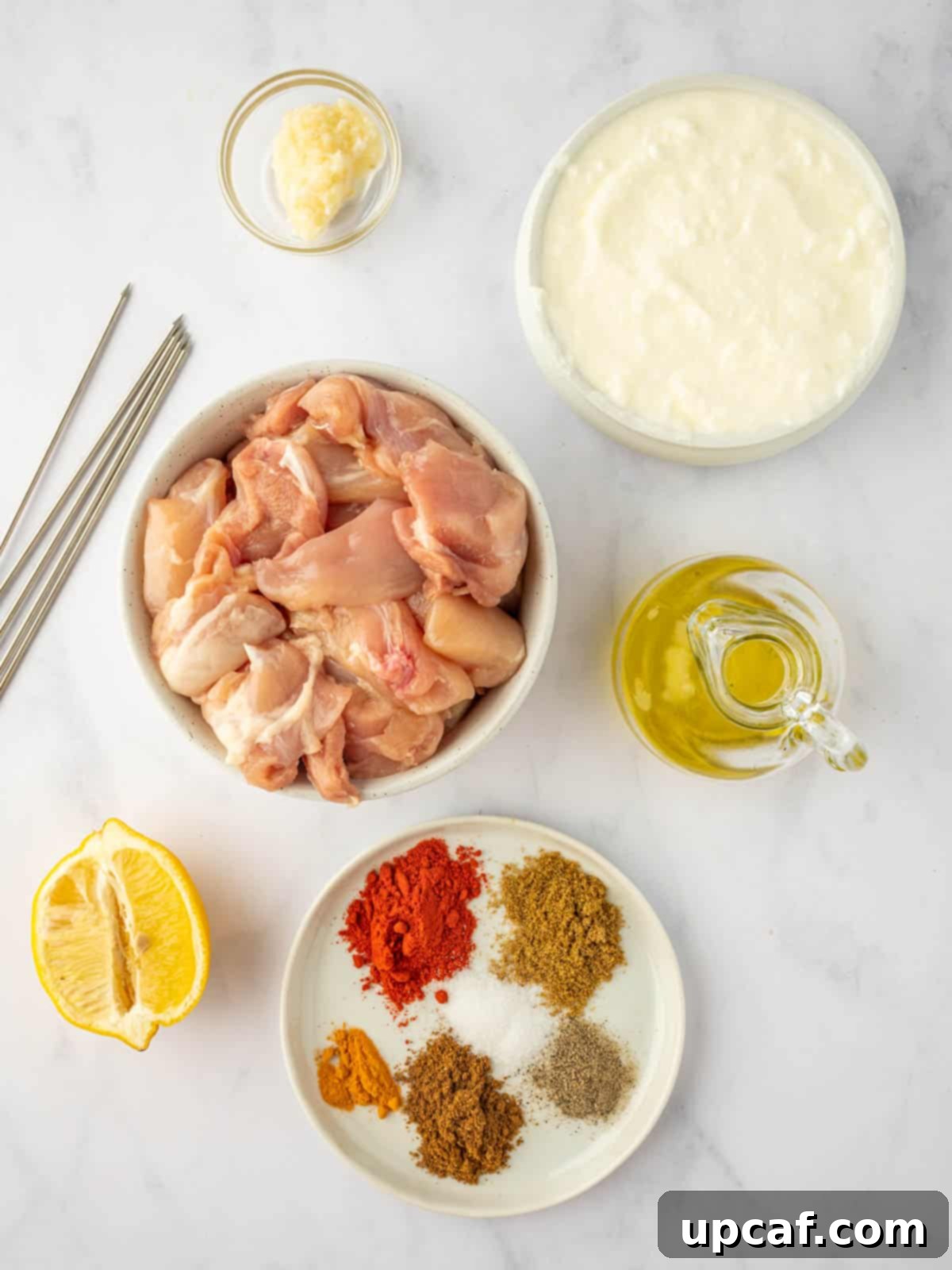 A vibrant selection of fresh ingredients and aromatic spices laid out for Tandoori chicken kebabs preparation.