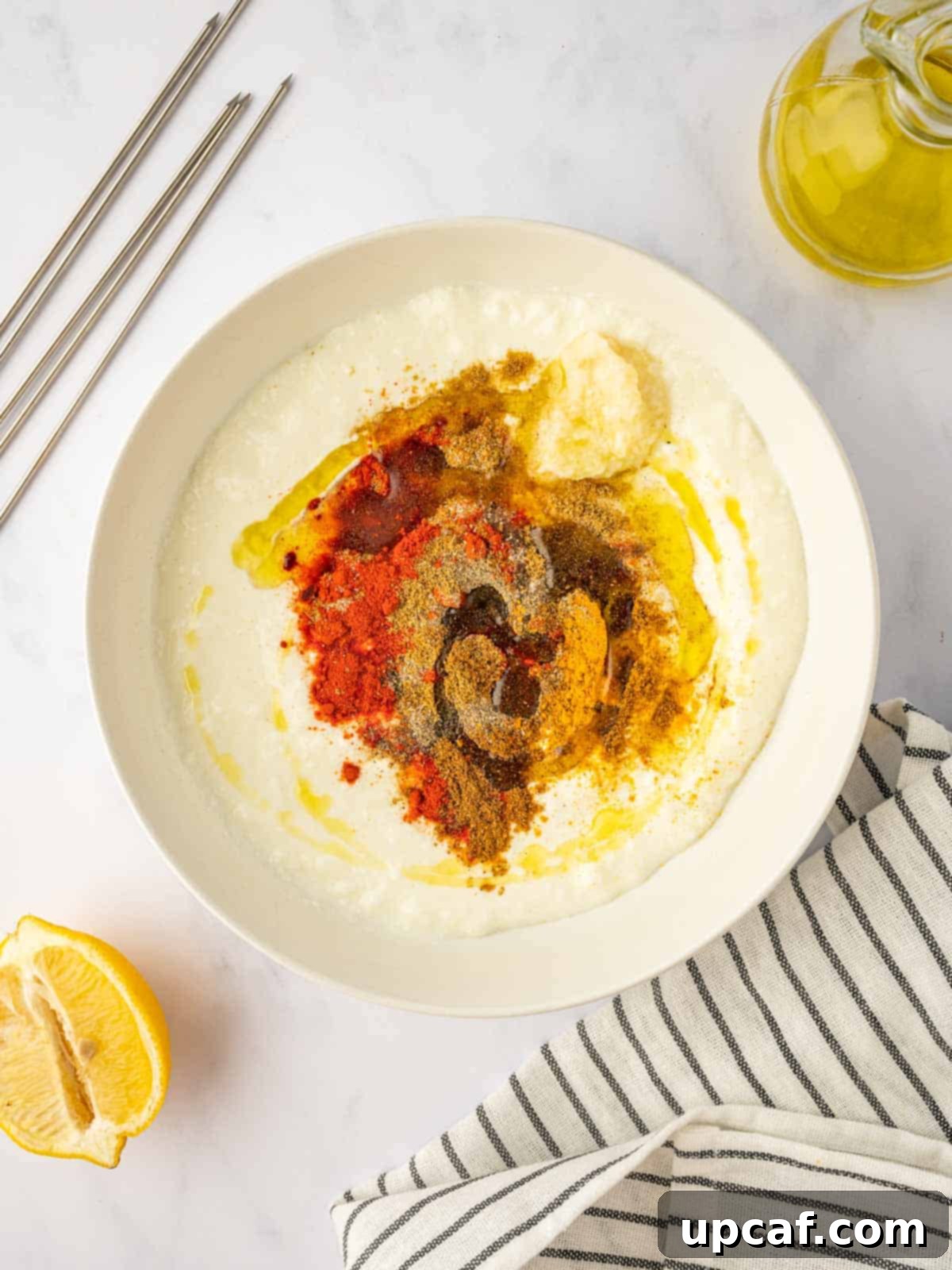 Expertly mixing plain yogurt and a variety of fragrant Tandoori spices in a bowl to create the rich marinade.