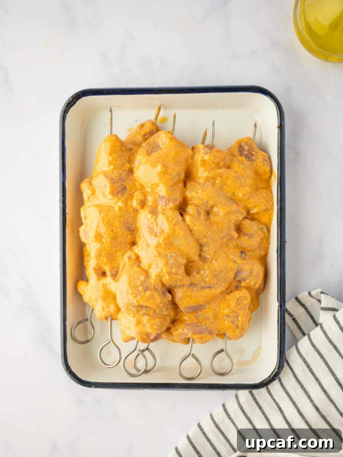 Perfectly marinated Tandoori chicken pieces expertly threaded onto wooden skewers, ready for grilling.