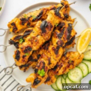 A vibrant plate of Tandoori chicken kebabs, expertly grilled and ready to be served.