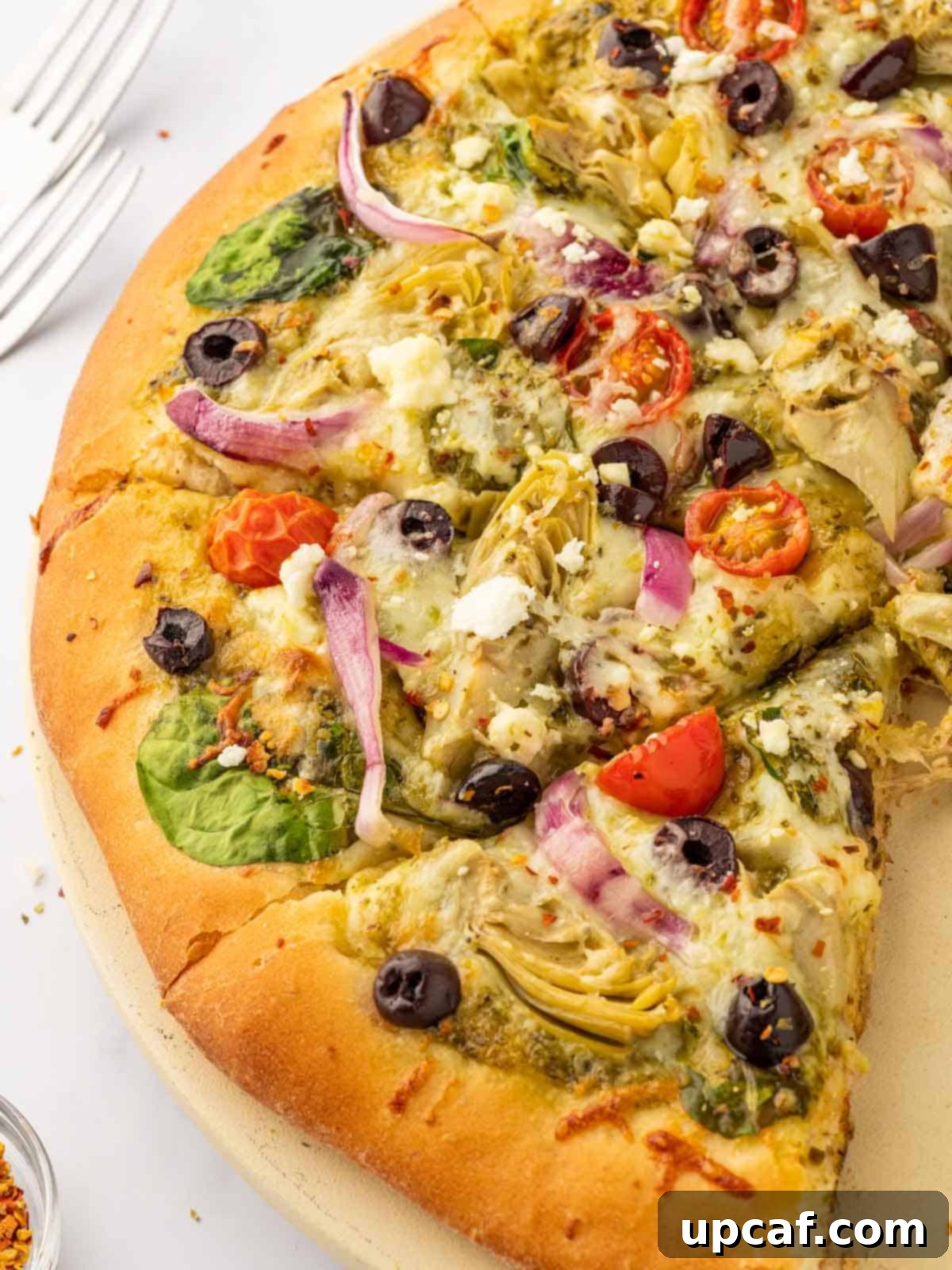 Close up of pizza with feta, artichokes and olives.