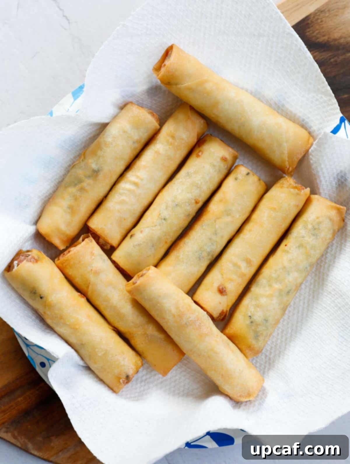 Freshly fried Lebanese Cheese Rolls draining on a paper towel after being removed from the oil.