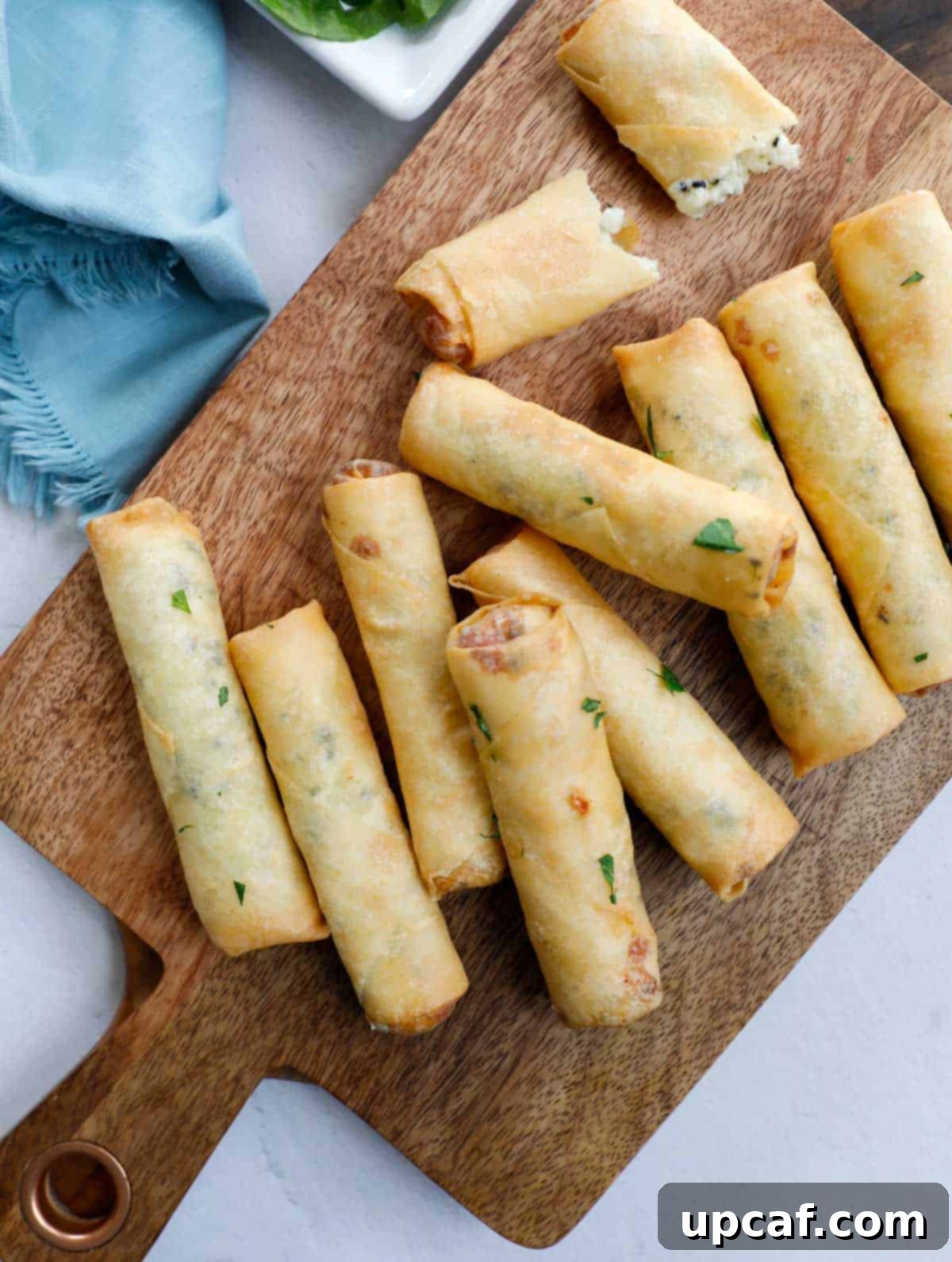 Another view of freshly fried Lebanese Cheese Rolls on a wooden board.