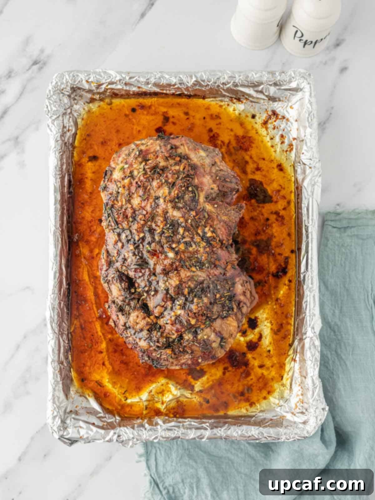 Rosemary Garlic Boneless Lamb Roast 6 Roasted leg of lamb in its juices in a baking dish lined with foil.