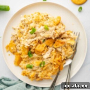 A portion of million dollar chicken is on a plate with 2 forks.