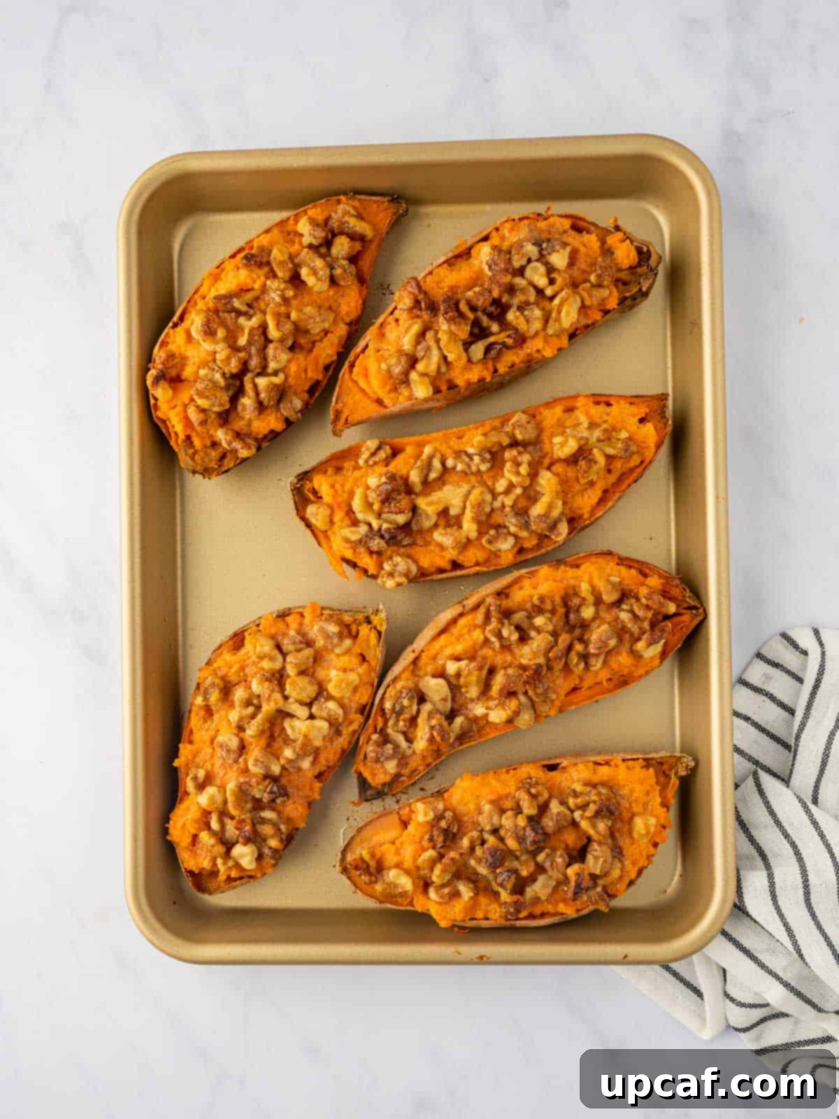 Maple Glazed Sweet Potatoes with Toasted Walnuts 9 A tray of double baked sweet potatoes, beautifully golden and topped with walnuts.