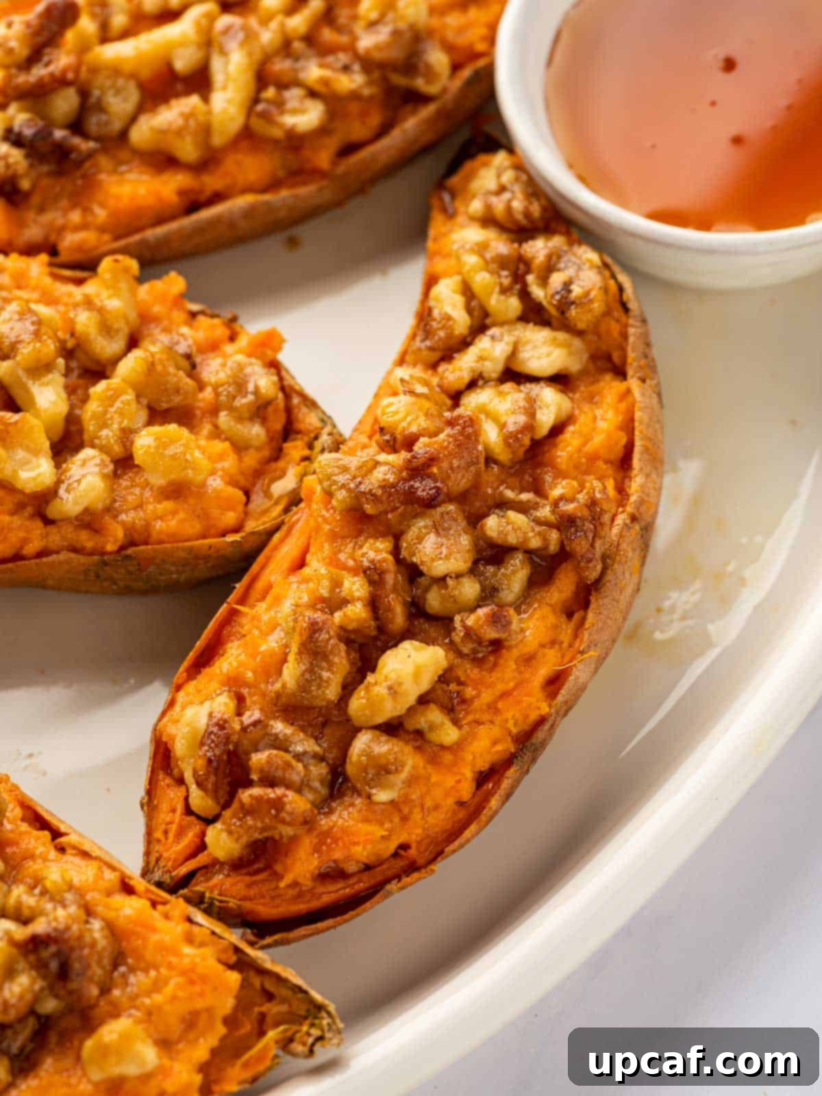 Maple Glazed Sweet Potatoes with Toasted Walnuts 10 Close-up of a double baked sweet potato with a golden walnut topping.