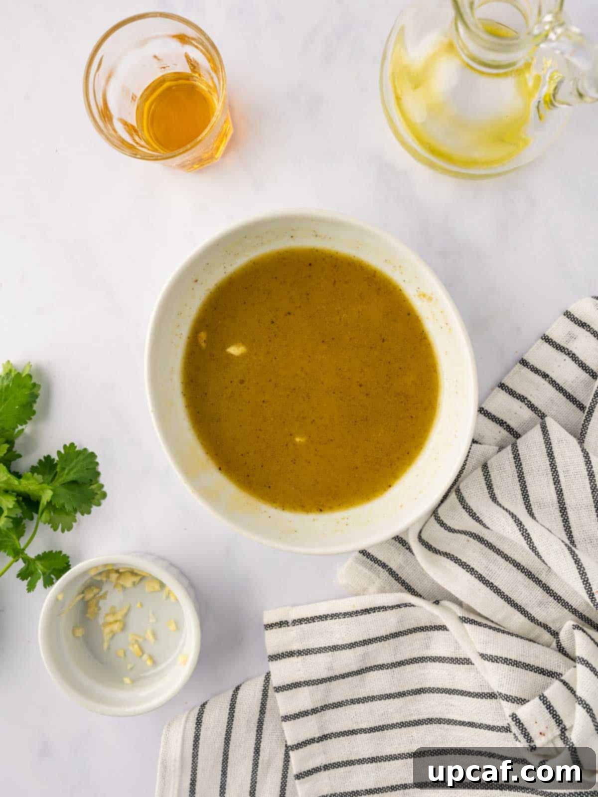 Roasted Sweet Potato Quinoa Salad 6 A small bowl of homemade salad dressing, consisting of olive oil, lime juice, maple syrup, and minced garlic.