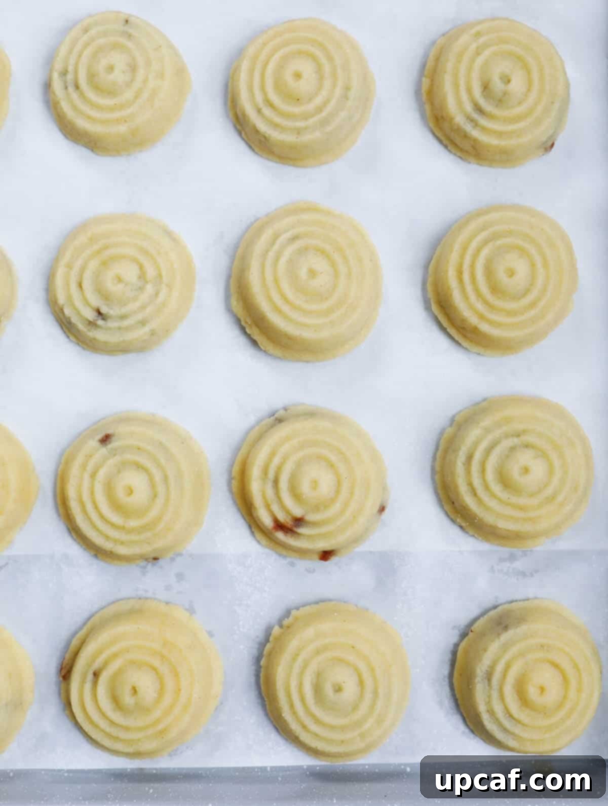 Maamoul date cookies on a sheet pan before baking.