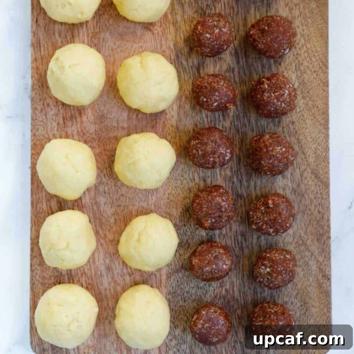 Maamoul dough balls and date balls prepped on a board.