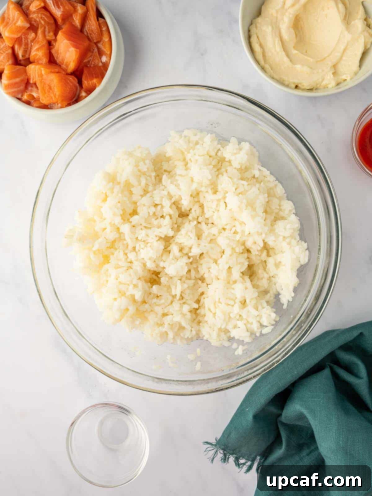 A bowl of perfectly cooked and fluffed white sushi rice, ready for seasoning.