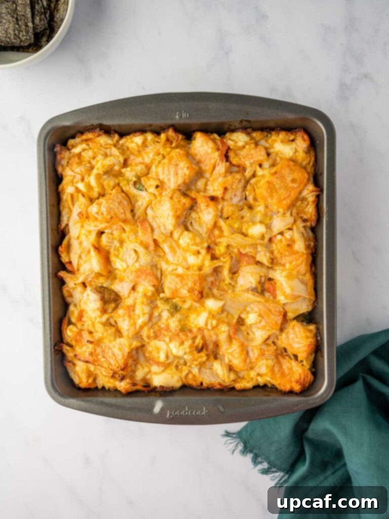 A close-up of the salmon layer on top of the rice in the baking pan, showing the rich, creamy texture.