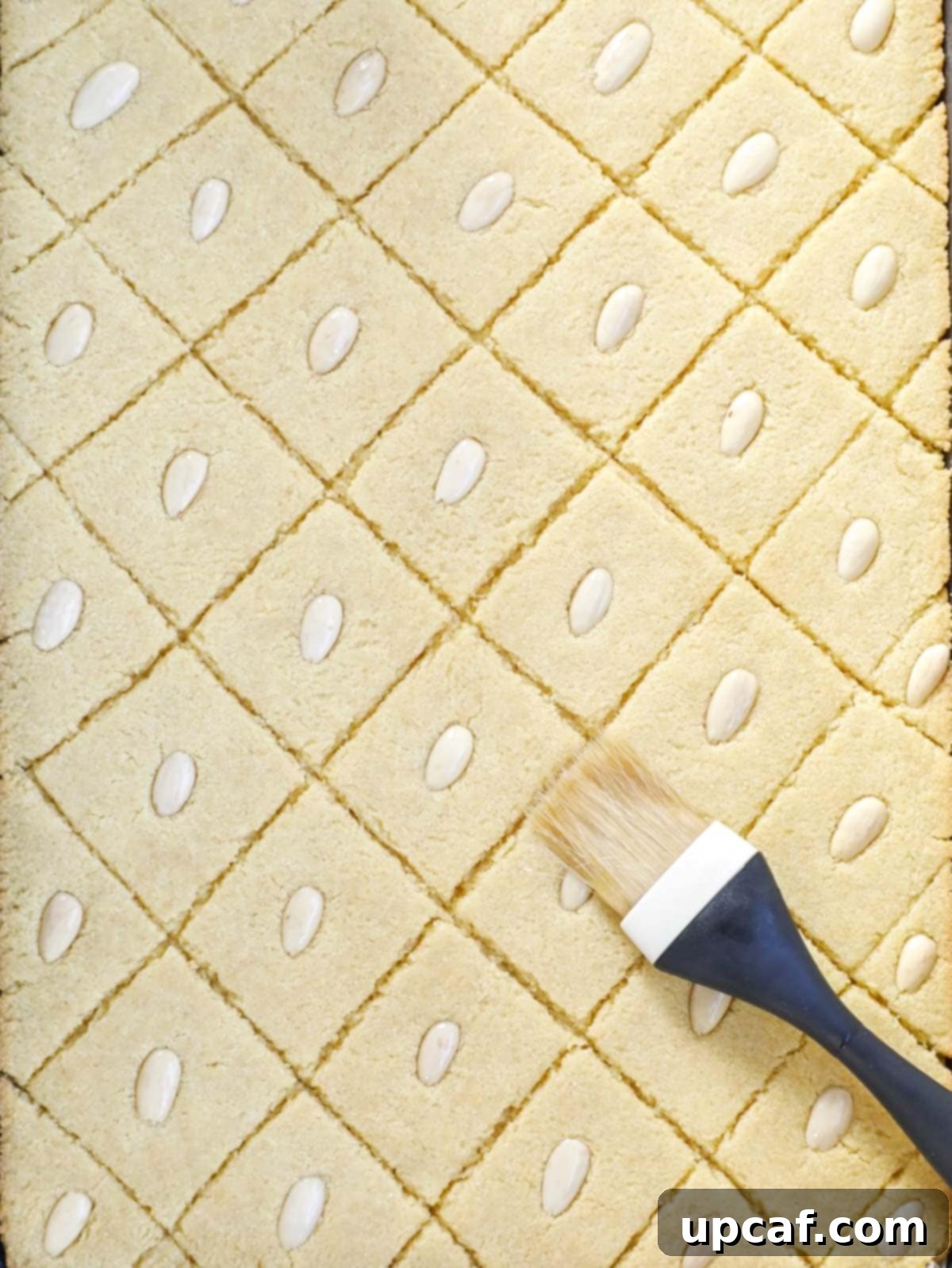 Namoura cake in the oven, midway through baking, being brushed with melted ghee or butter for a richer crust.