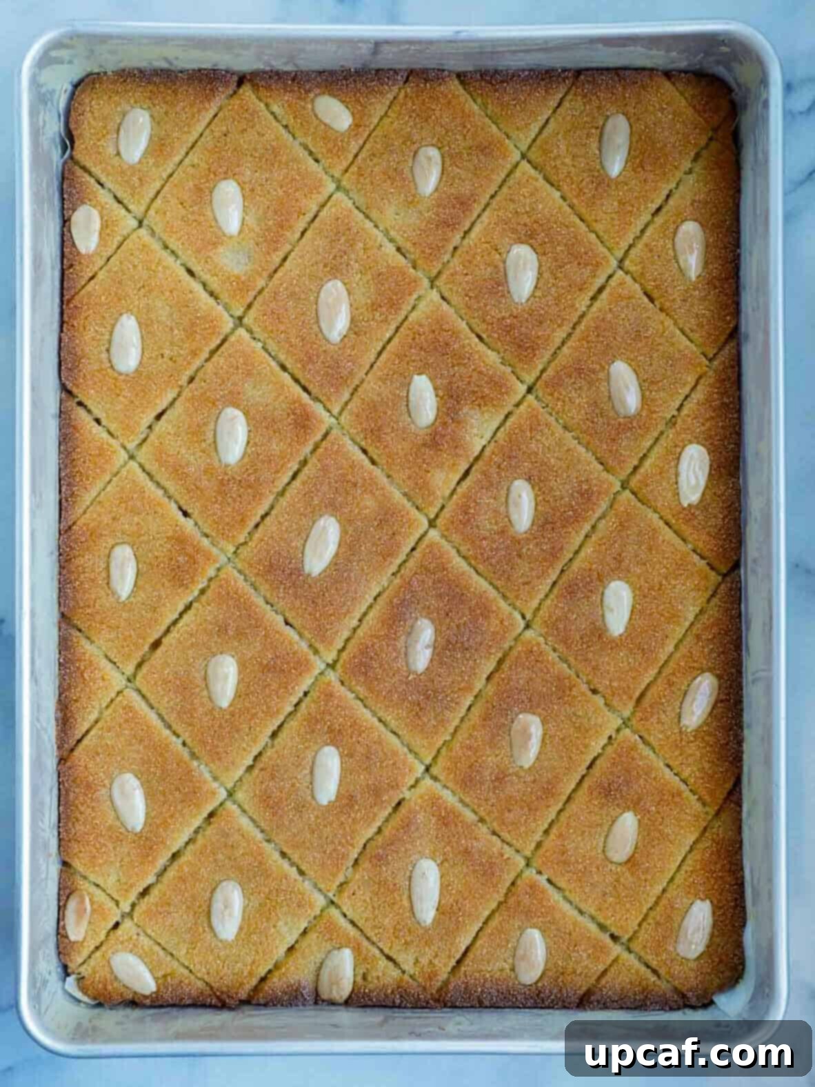 A freshly baked Namoura cake, golden brown and glistening, in the pan, moments after being removed from the oven.