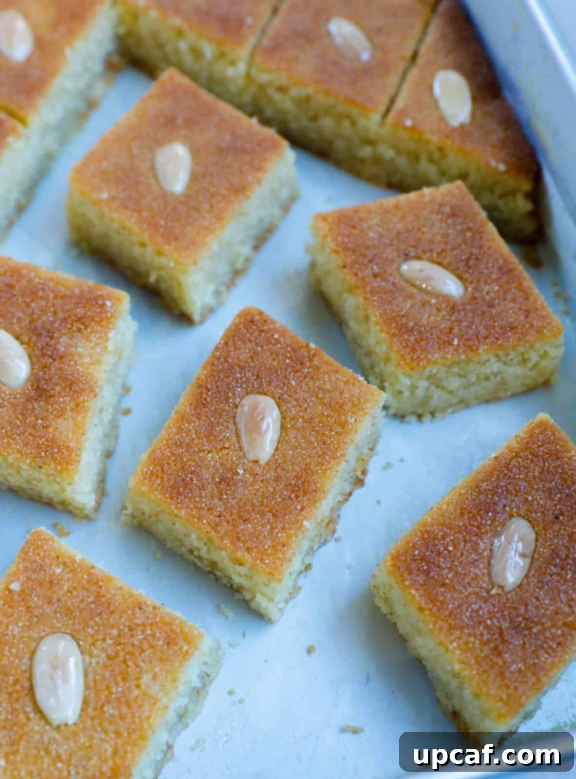 A close-up view of a thick slice of Namoura, showing its moist crumb and slightly browned side.