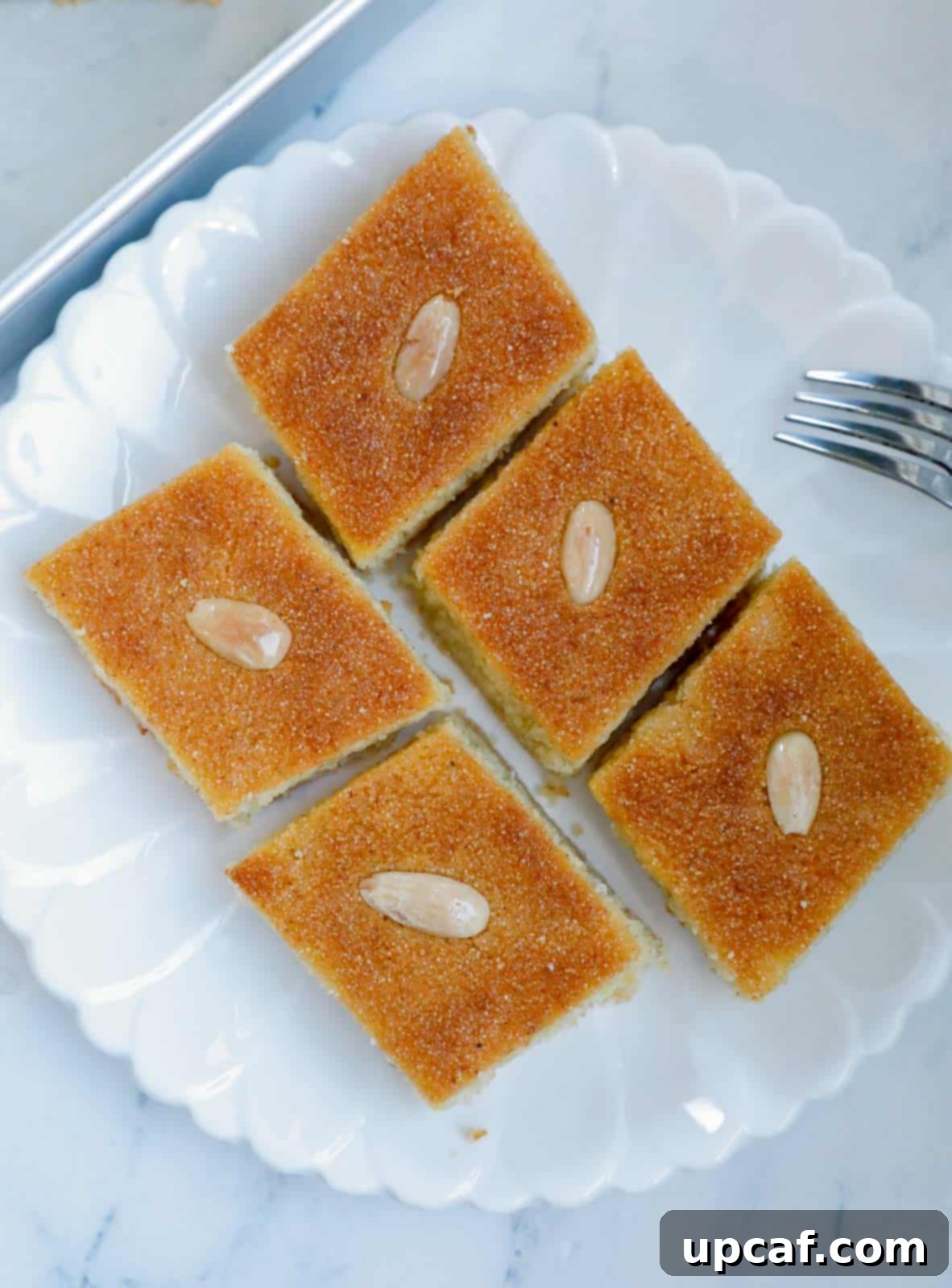 Several pieces of Namoura artfully arranged on a white plate, ready to be served.