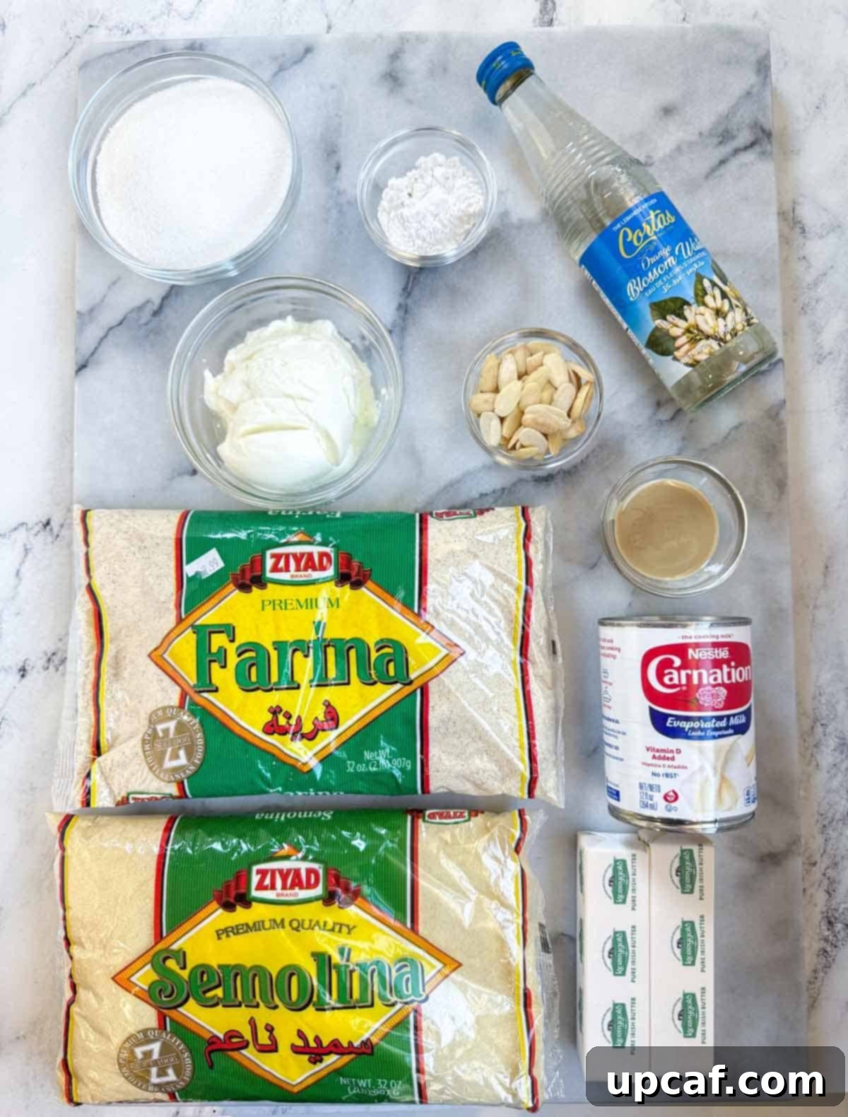 A beautiful flat lay of all the fresh ingredients required for making the Namoura recipe, including semolina, yogurt, butter, and almonds.