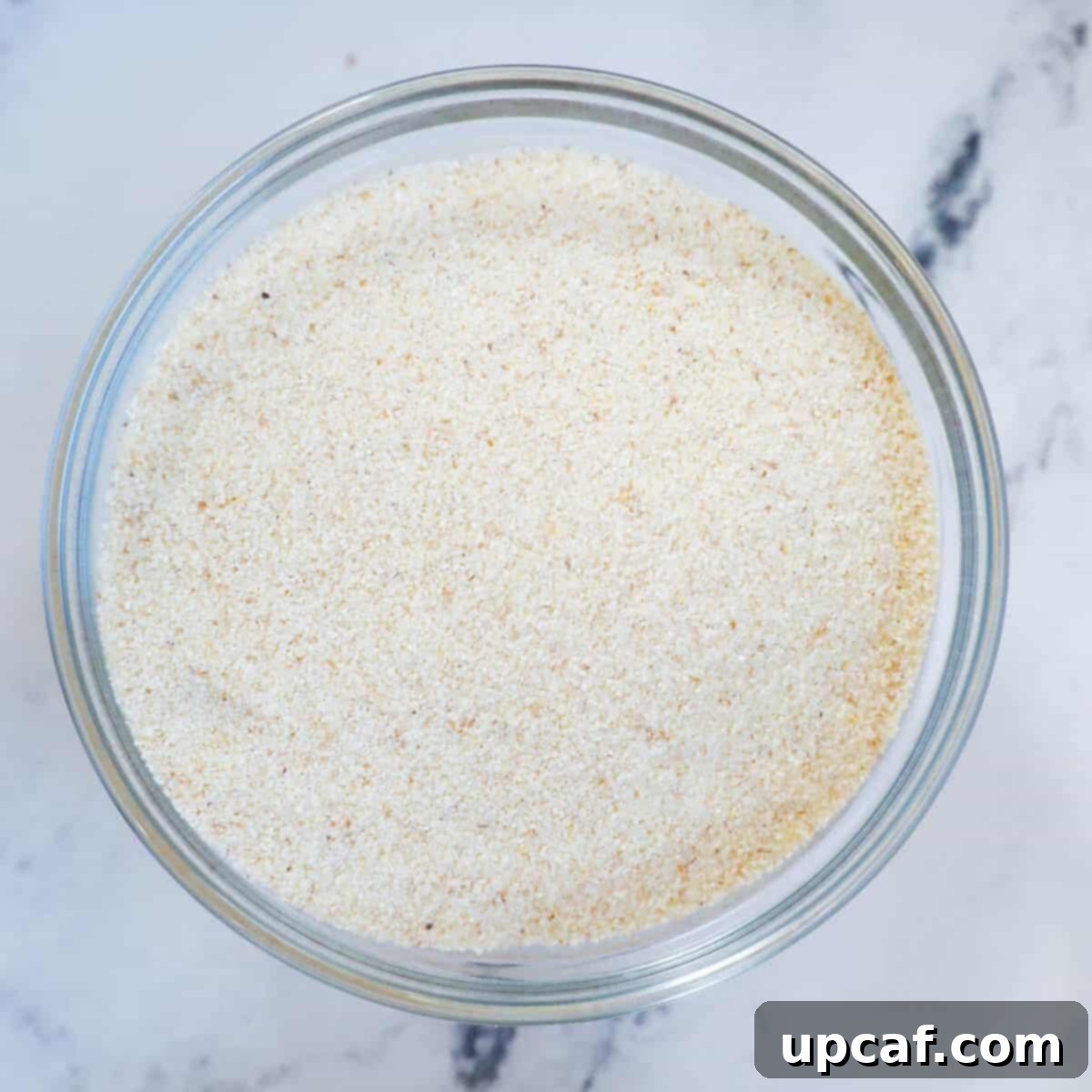 Close-up of coarse semolina in a bowl, showing its gritty, granular texture.