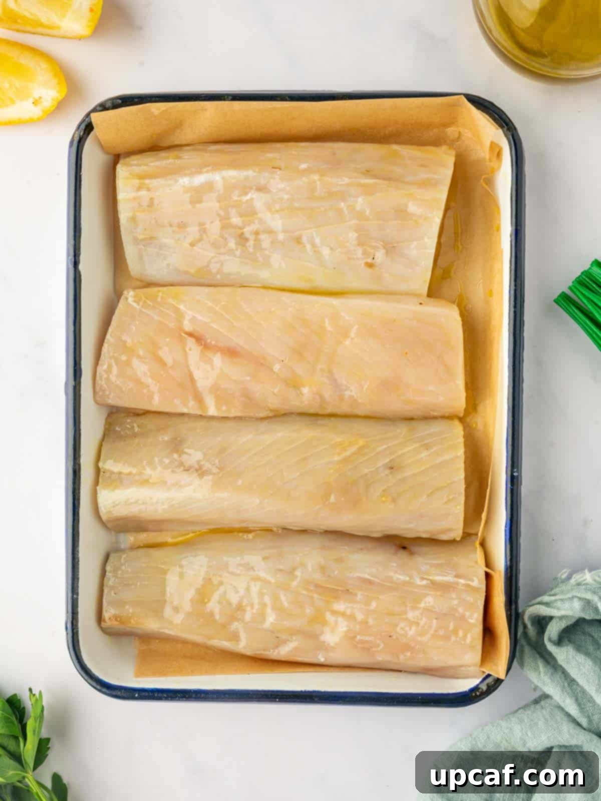 A raw mahi mahi fish fillet perfectly positioned on a pan, showcasing its fresh texture and vibrant color before the cooking process begins.
