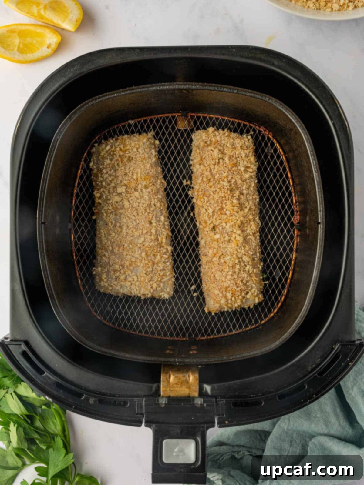 Breaded Mahi Mahi fish fillets neatly arranged in the air fryer basket, ready for cooking and soon to be transformed into a golden, crispy meal.