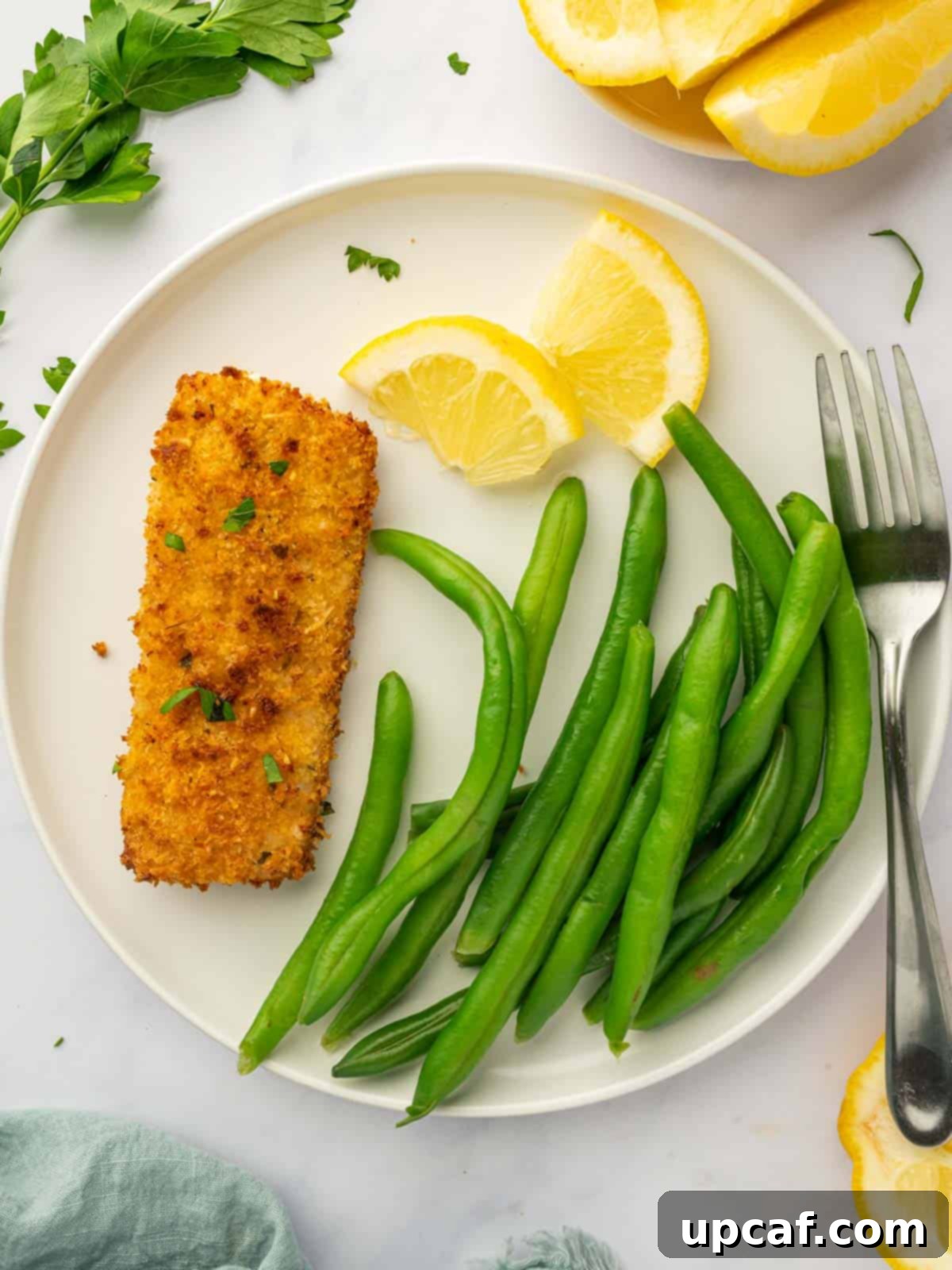 A perfectly air-fried mahi mahi fillet served alongside vibrant green beans, showcasing a balanced and healthy meal presentation.
