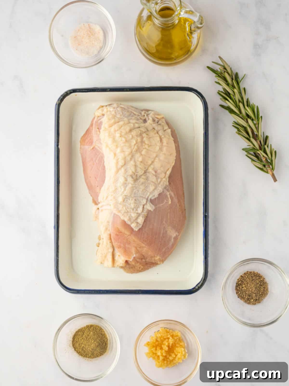 Ingredients for air fryer turkey breast including fresh rosemary, garlic, and various spices.