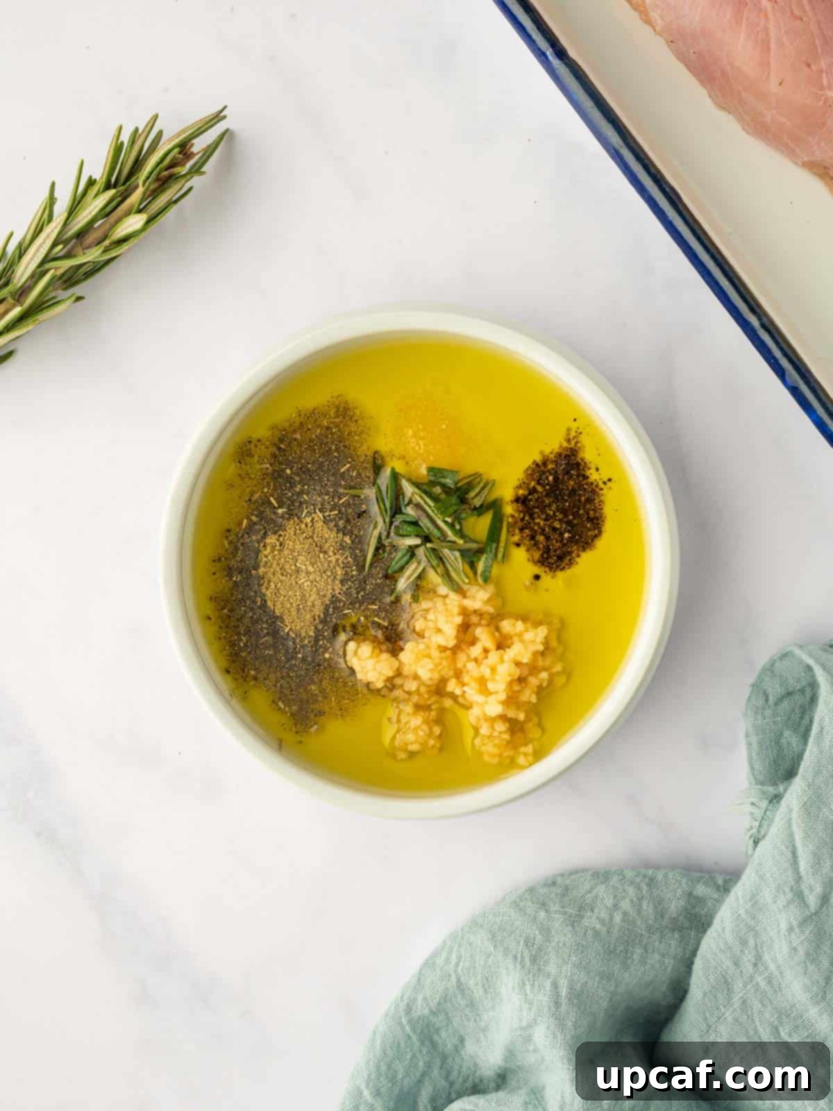 Olive oil and spices being mixed together to create a seasoning mixture for turkey breast.