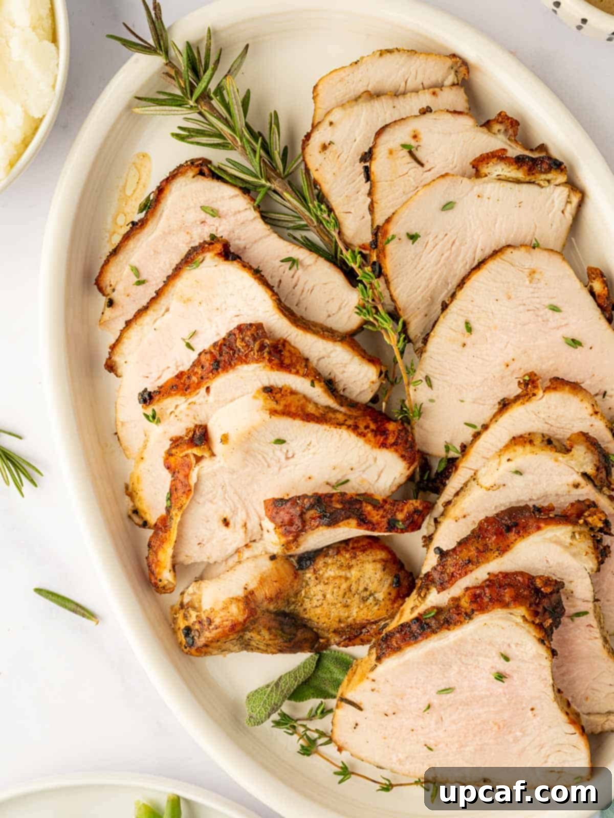 Perfectly cooked slices of turkey breast on a serving platter.