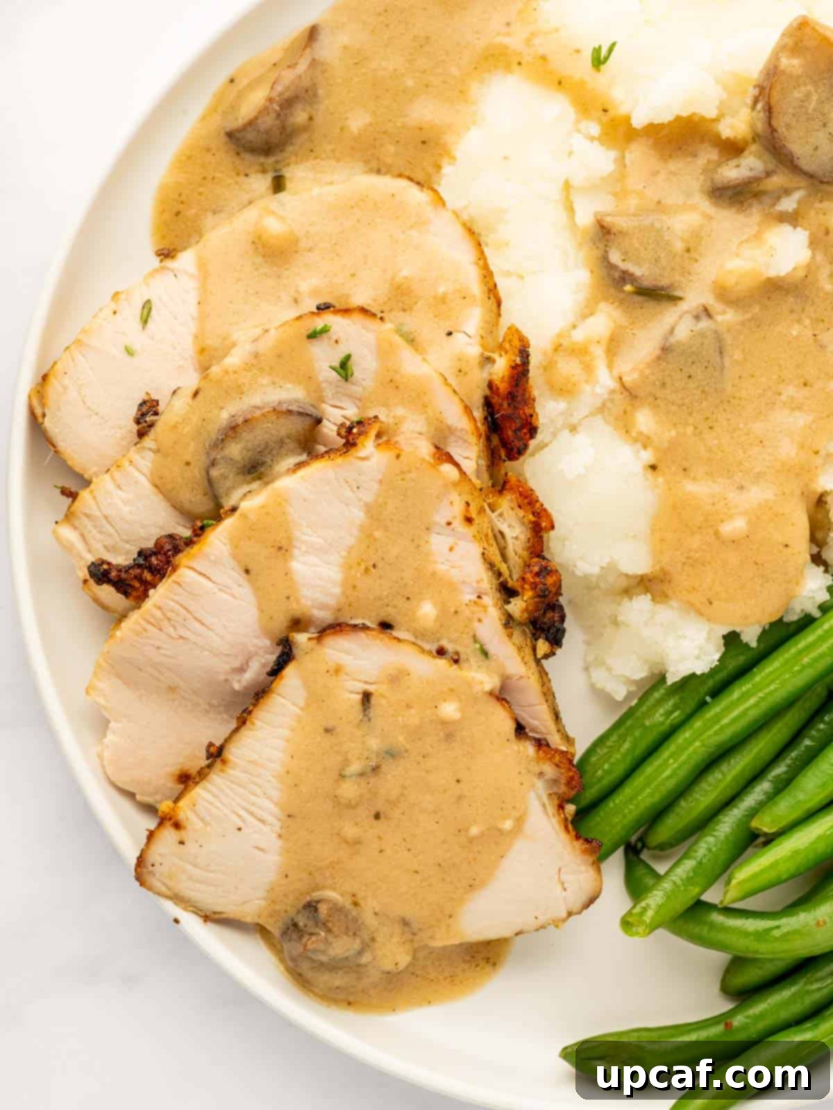 Slices of golden turkey breast generously topped with rich, homemade gravy.