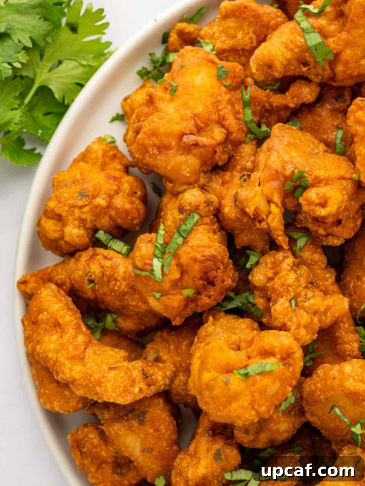 Golden Crispy Chicken Pakora 10 A close-up shot revealing the crispy, textured coating of chicken pakora, served hot on a platter.