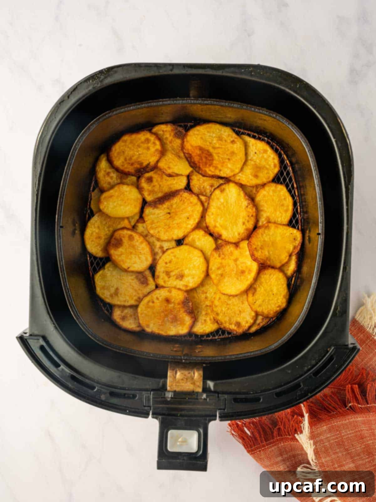 Golden Air-Fried Potato Coins 8 Golden, crispy potatoes perfectly cooked and arranged in an air fryer basket.