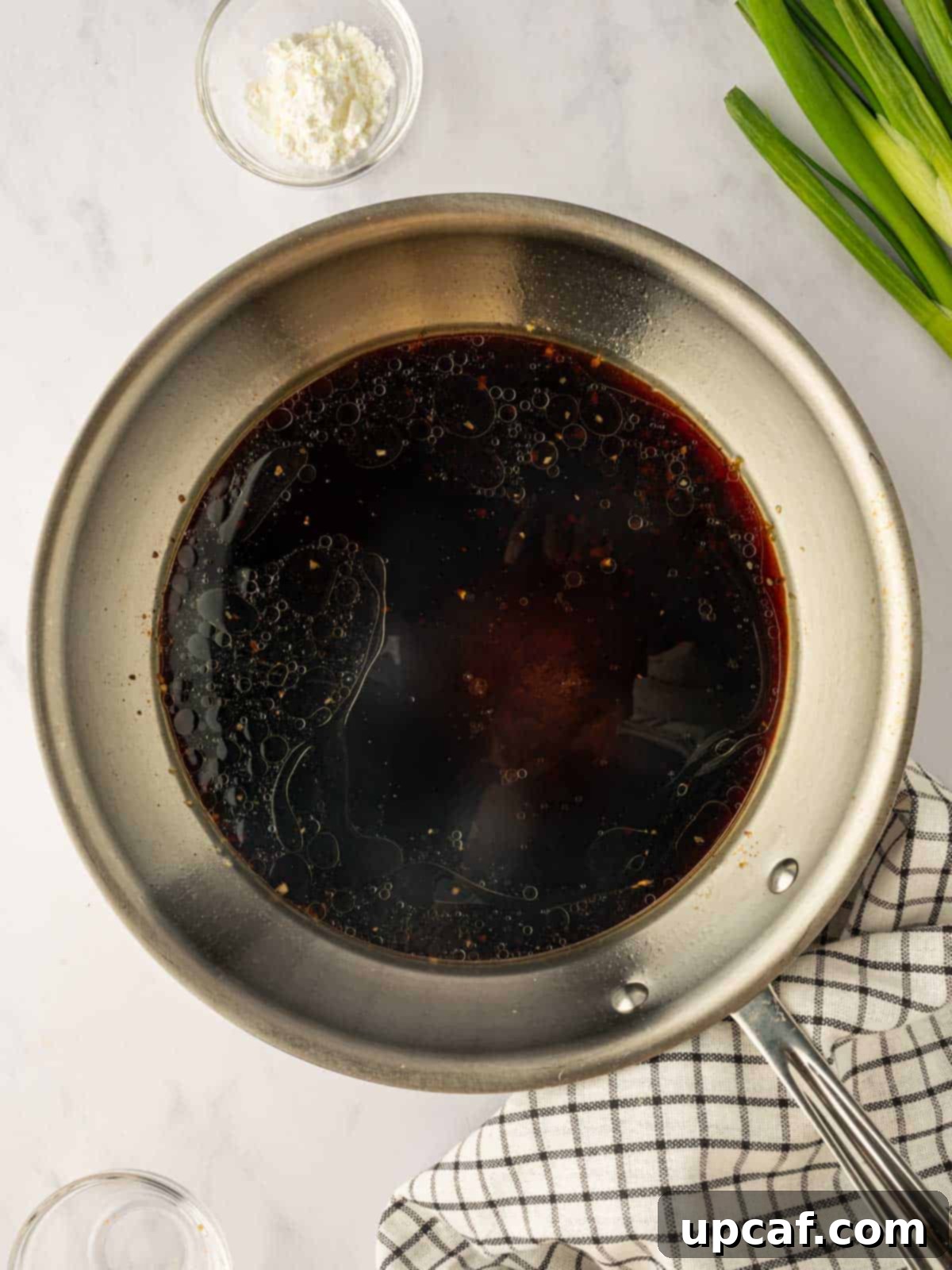 Sweet and Sticky Panda Express Teriyaki Chicken 6 Homemade teriyaki sauce simmering and thickening in a skillet.