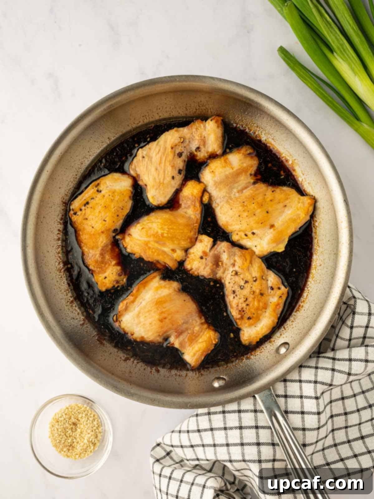 Sweet and Sticky Panda Express Teriyaki Chicken 7 Cooked chicken thighs simmering in the homemade teriyaki sauce in a skillet, soaking up the flavors.