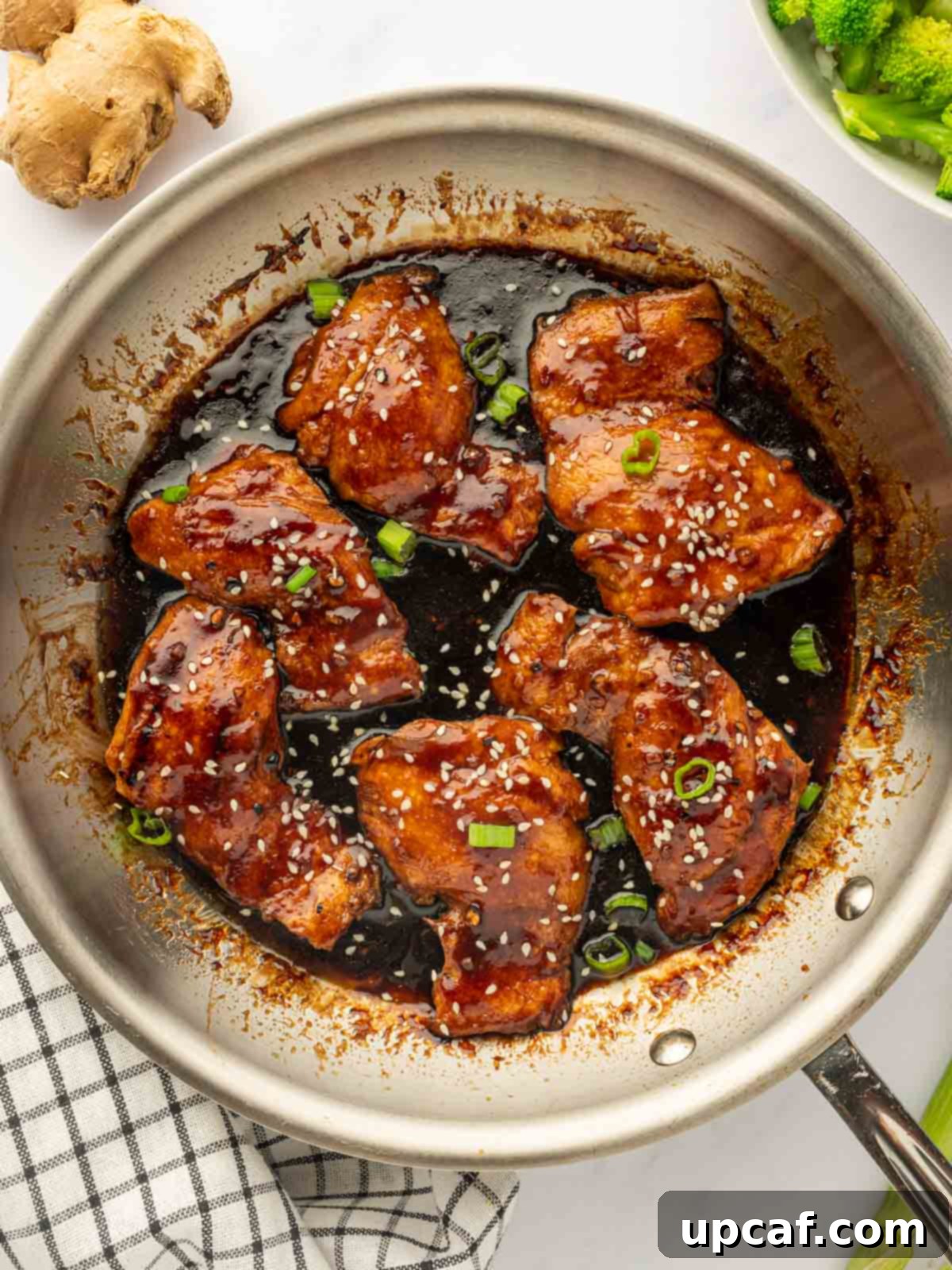 Sweet and Sticky Panda Express Teriyaki Chicken 8 Teriyaki chicken in a skillet, beautifully garnished with chopped green onions and sesame seeds, ready to be served.