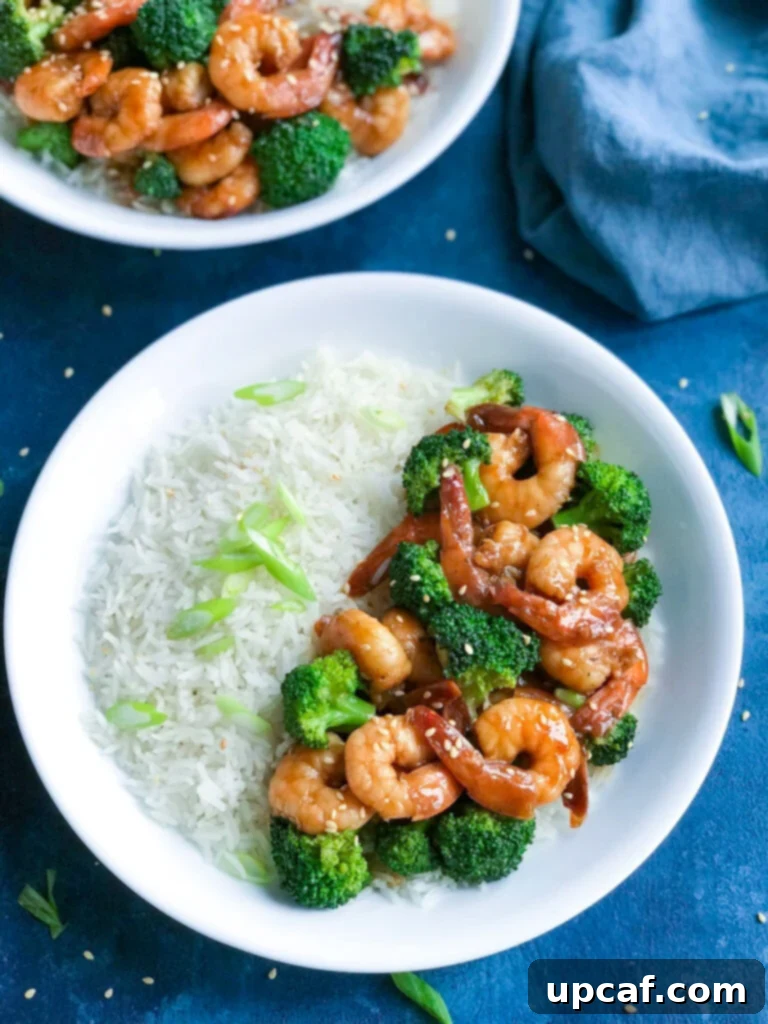 Overhead shot of vibrant Teriyaki Shrimp served with fluffy white rice and steamed green broccoli florets on a pristine plate, ready to eat.