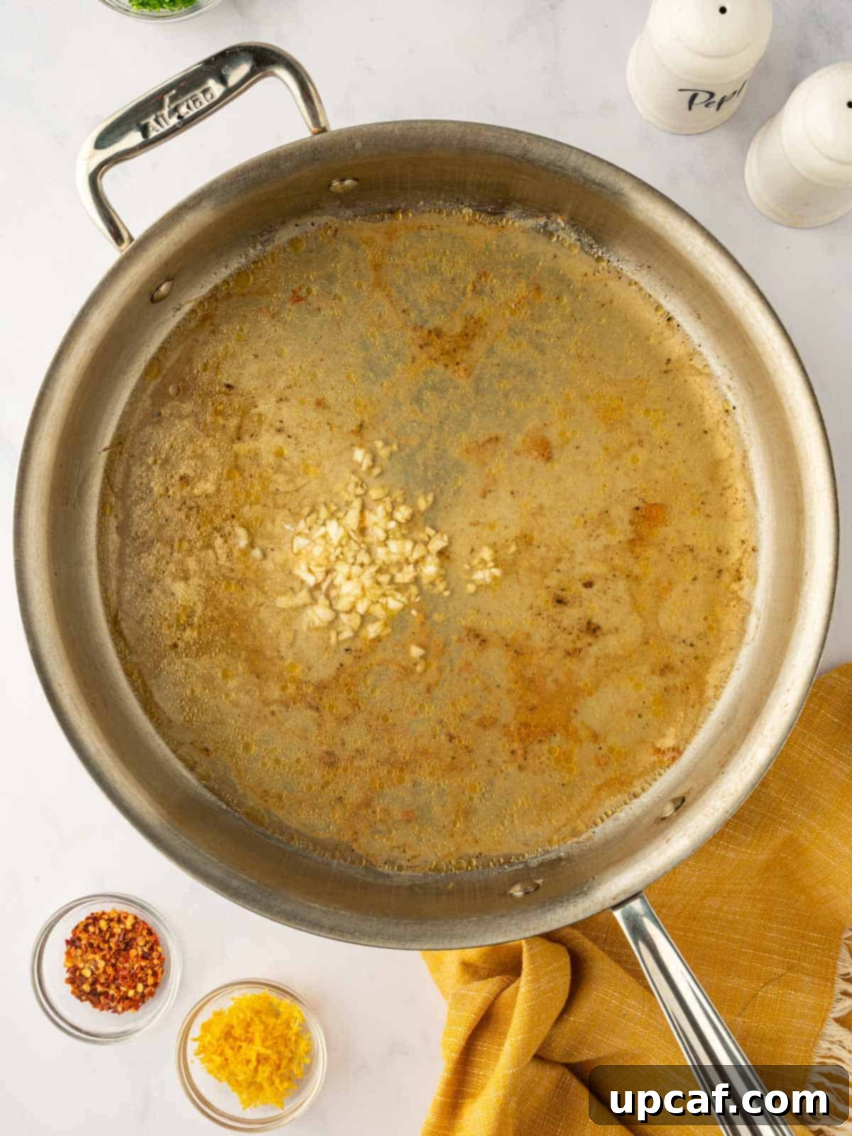 Preparing the scampi sauce in a skillet.