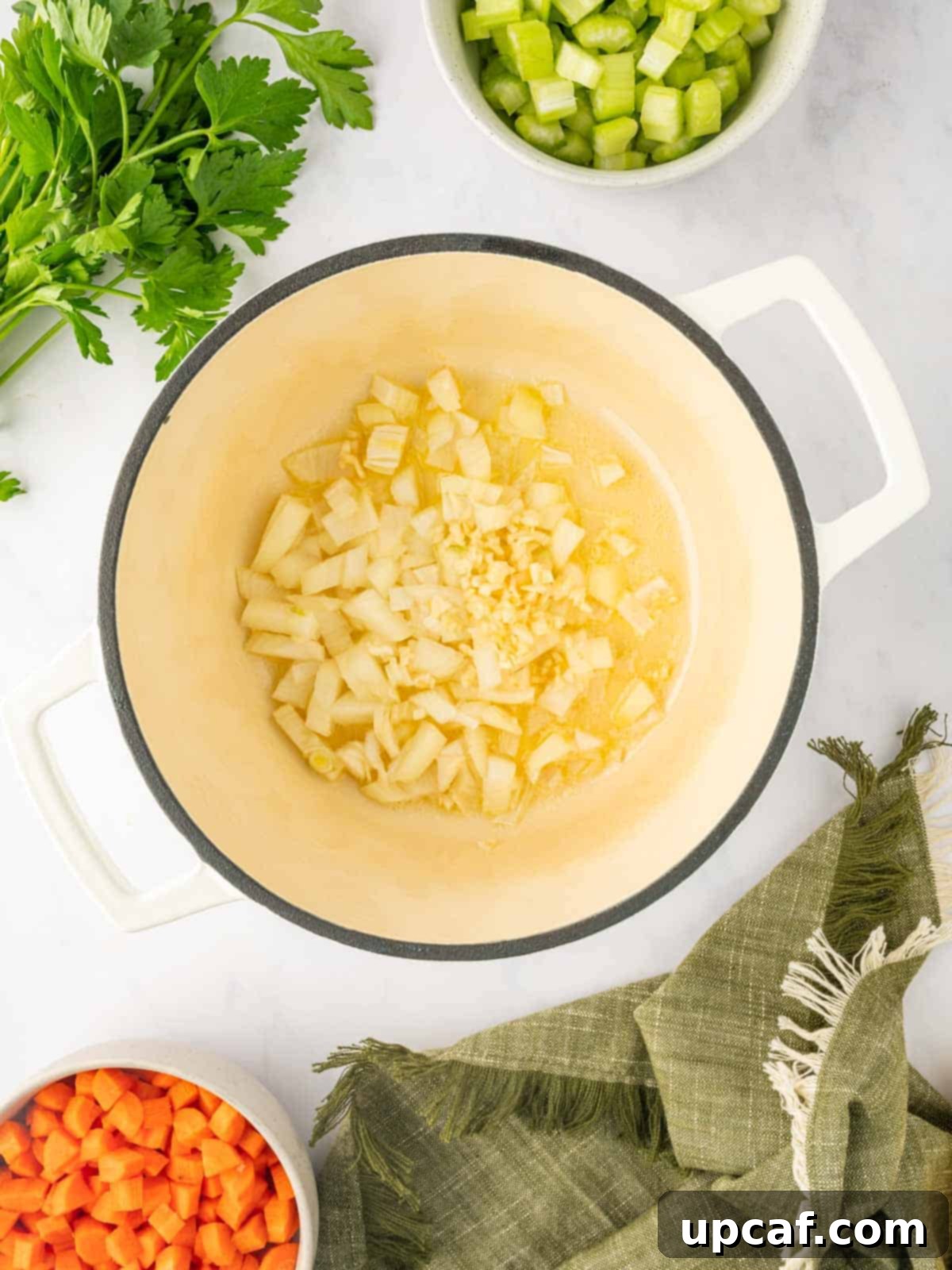 Comforting Italian Pastina Soup 4 Diced onions and minced garlic being sautéed in a Dutch oven.