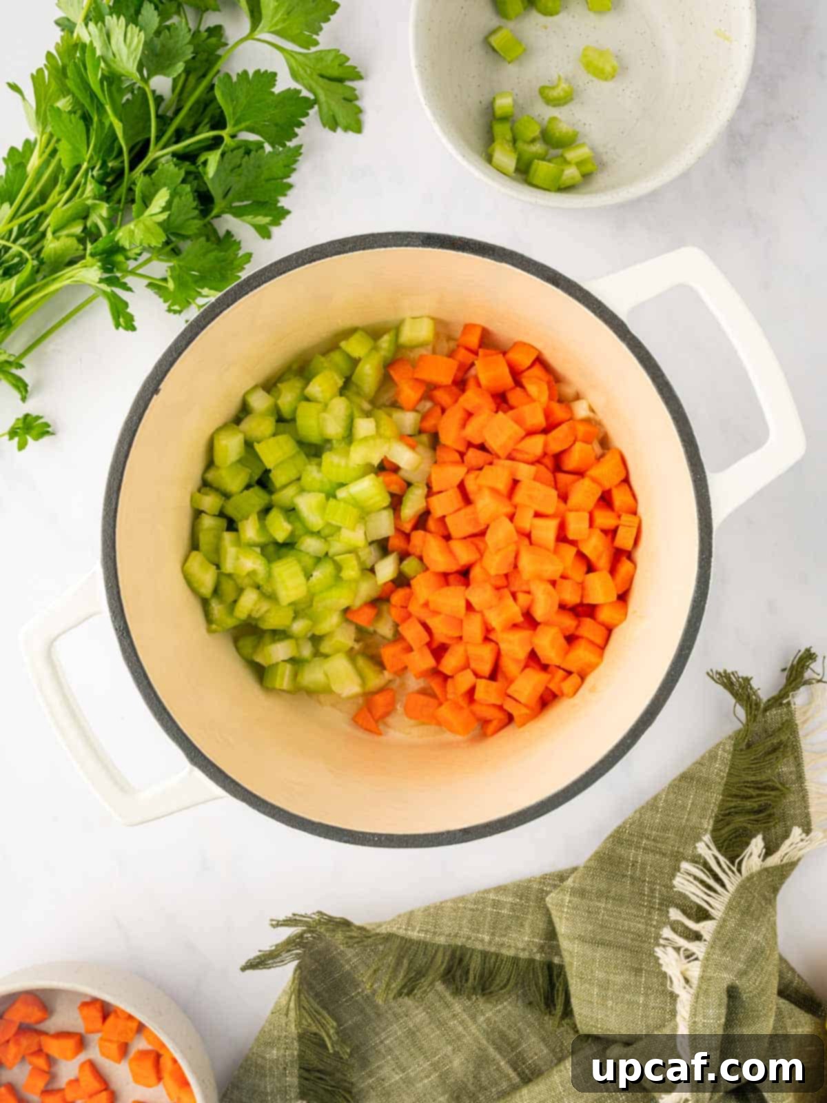 Comforting Italian Pastina Soup 5 Chopped celery and carrots being added to the sautéed onions and garlic in a Dutch oven.