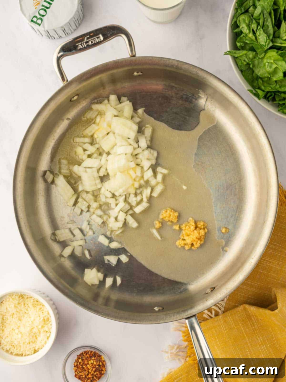 Chopped onions and minced garlic sautéing in melted butter in a large skillet, releasing their fragrant aromas.